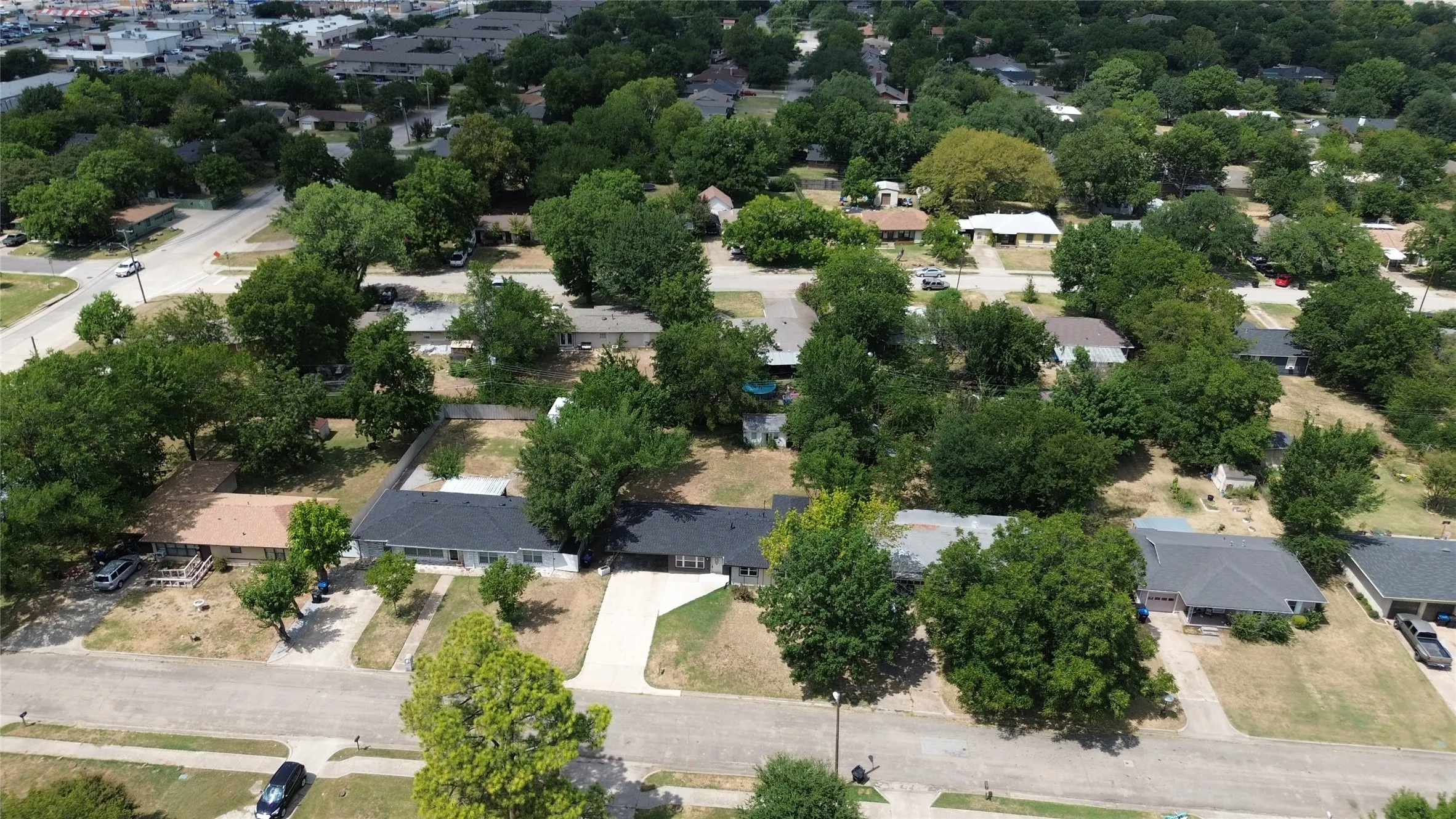 Residential neighborhood with mature trees, paved streets, and single-story properties
