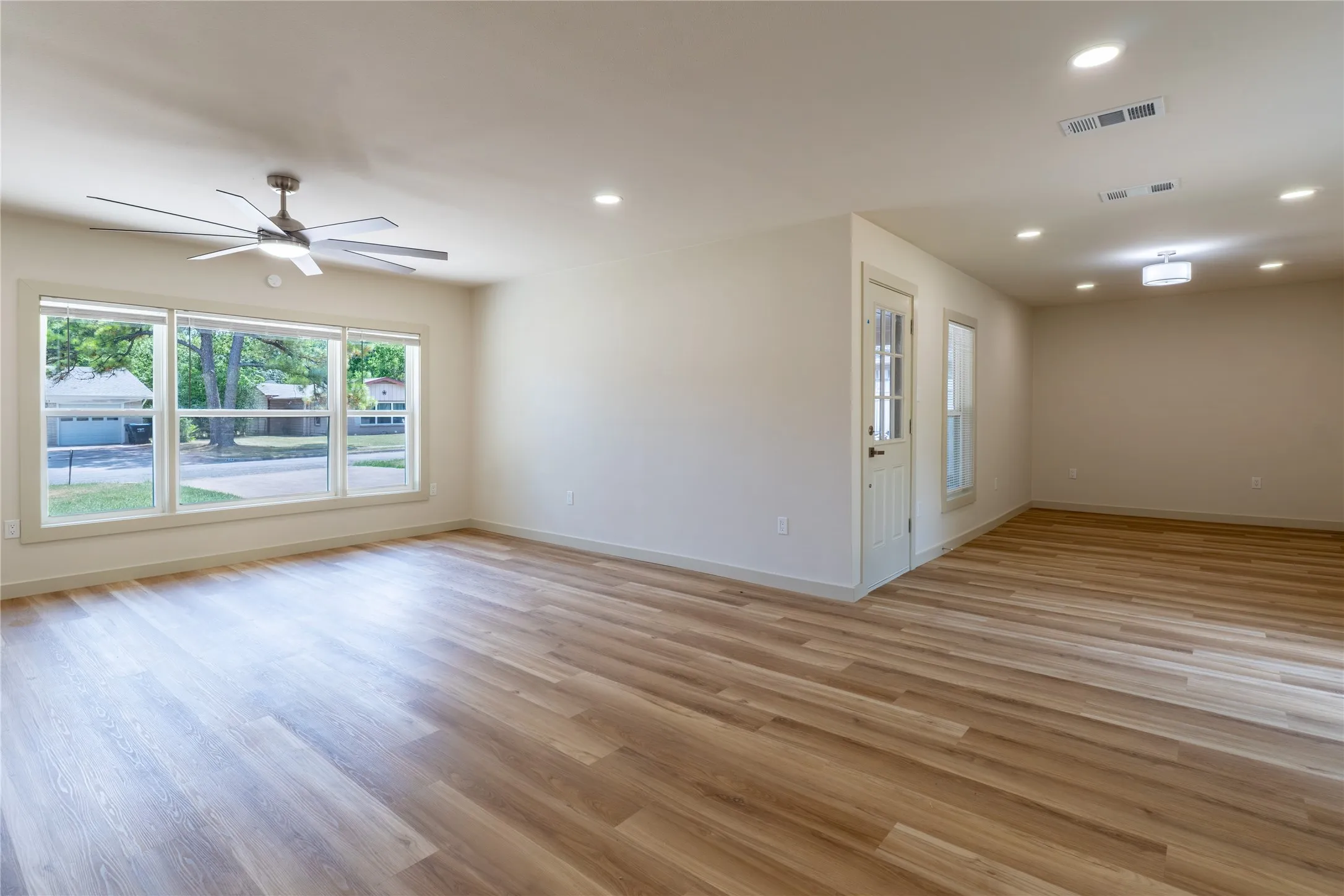 Spacious interior with wood-finish flooring, recessed lighting, and multiple windows