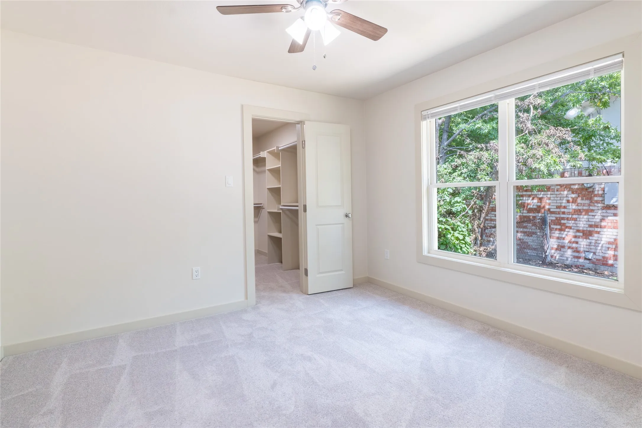 Plush carpeting, bright white walls, and a large window with white trim