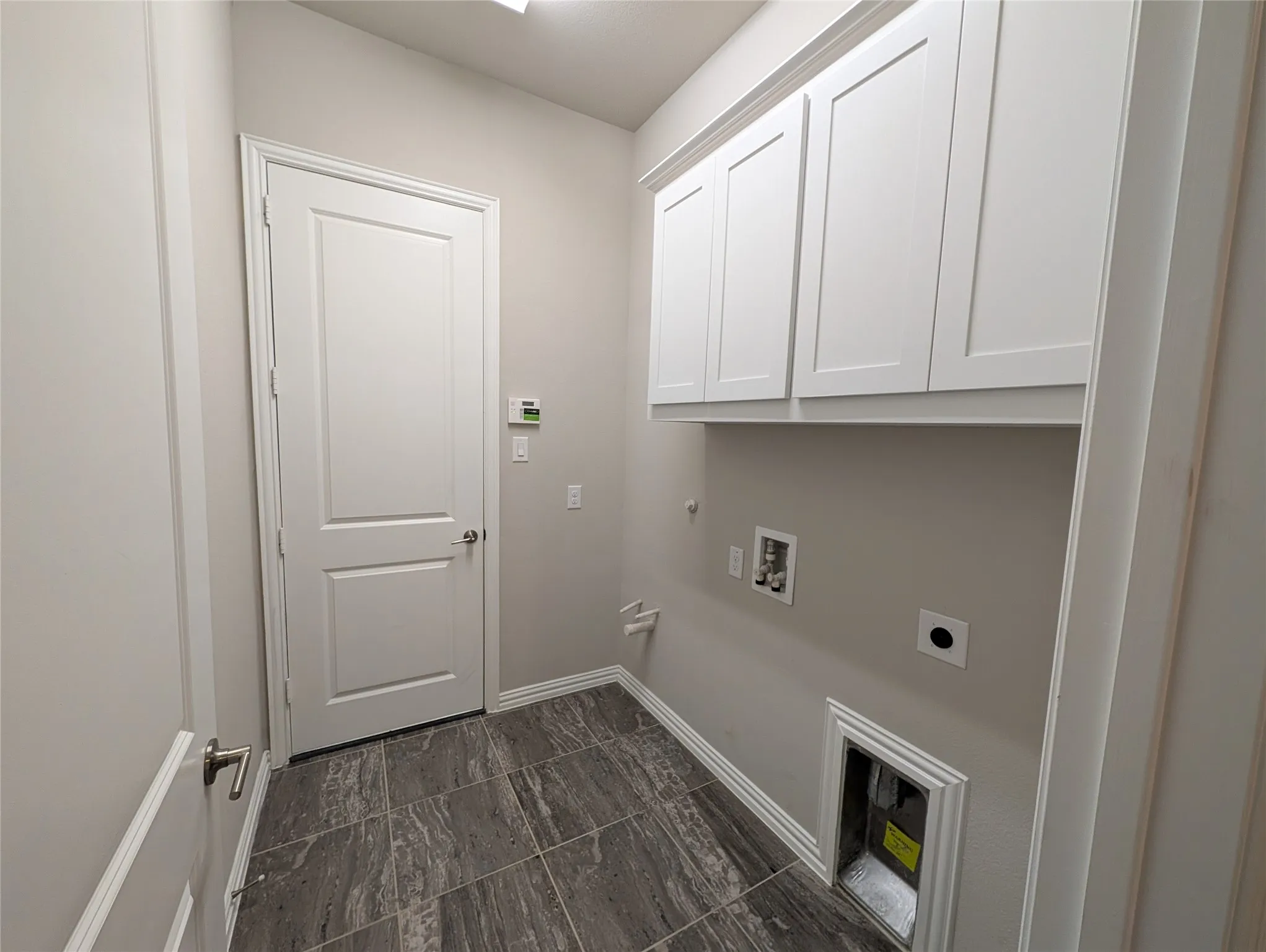 Gray tile flooring, white shaker-style cabinetry, and white trim