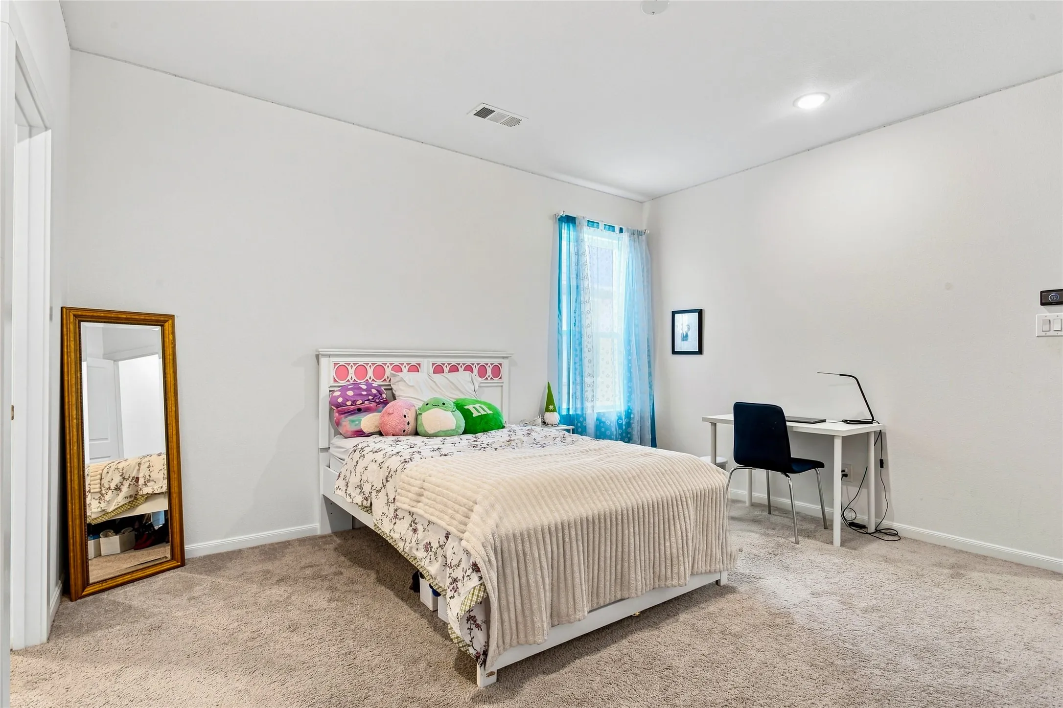 Carpeted room featuring a window with sheer blue curtains, recessed lighting, and a white baseboard trim