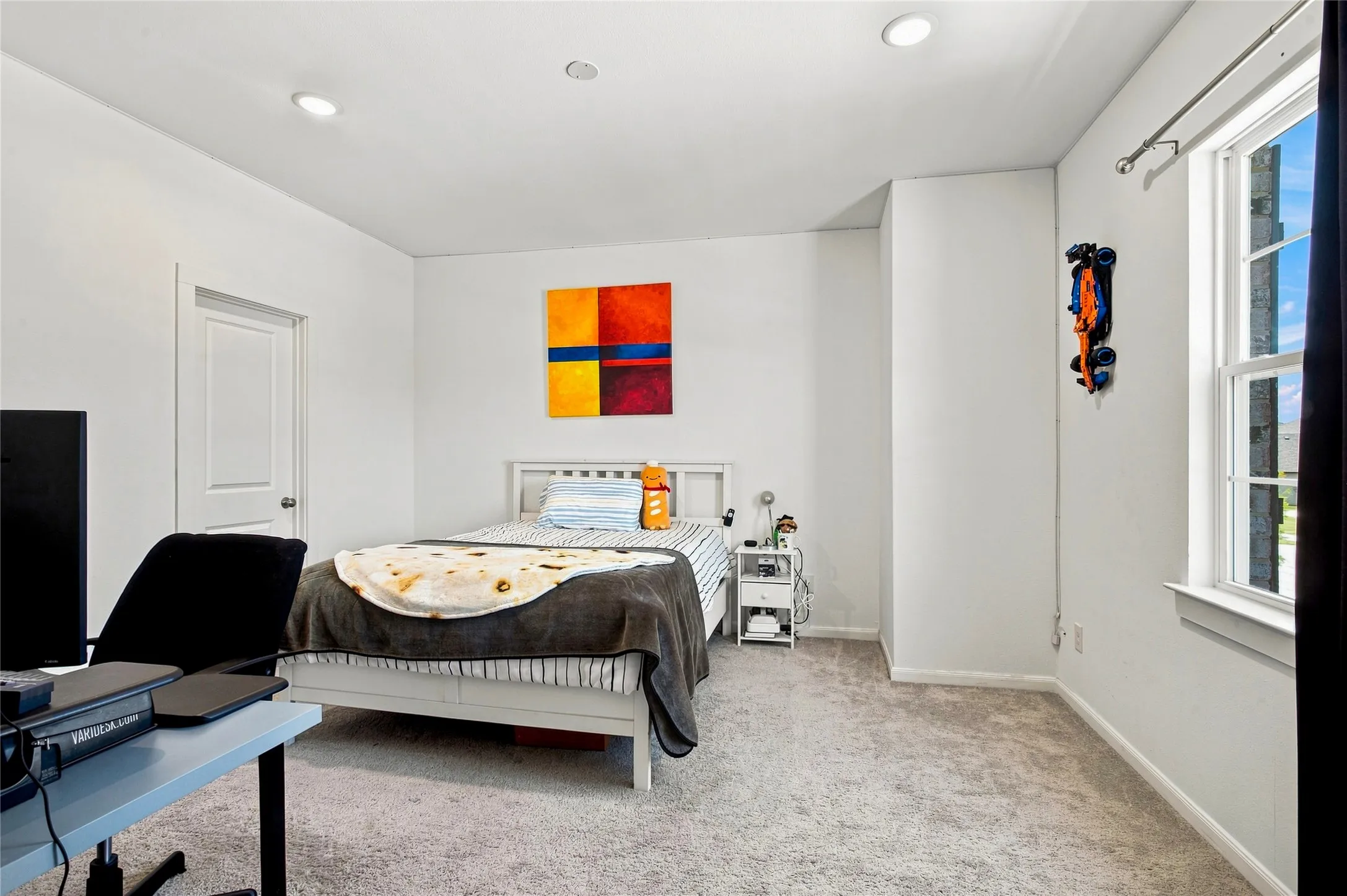 Carpeted room featuring a double-hung window, recessed lighting, and a white interior door