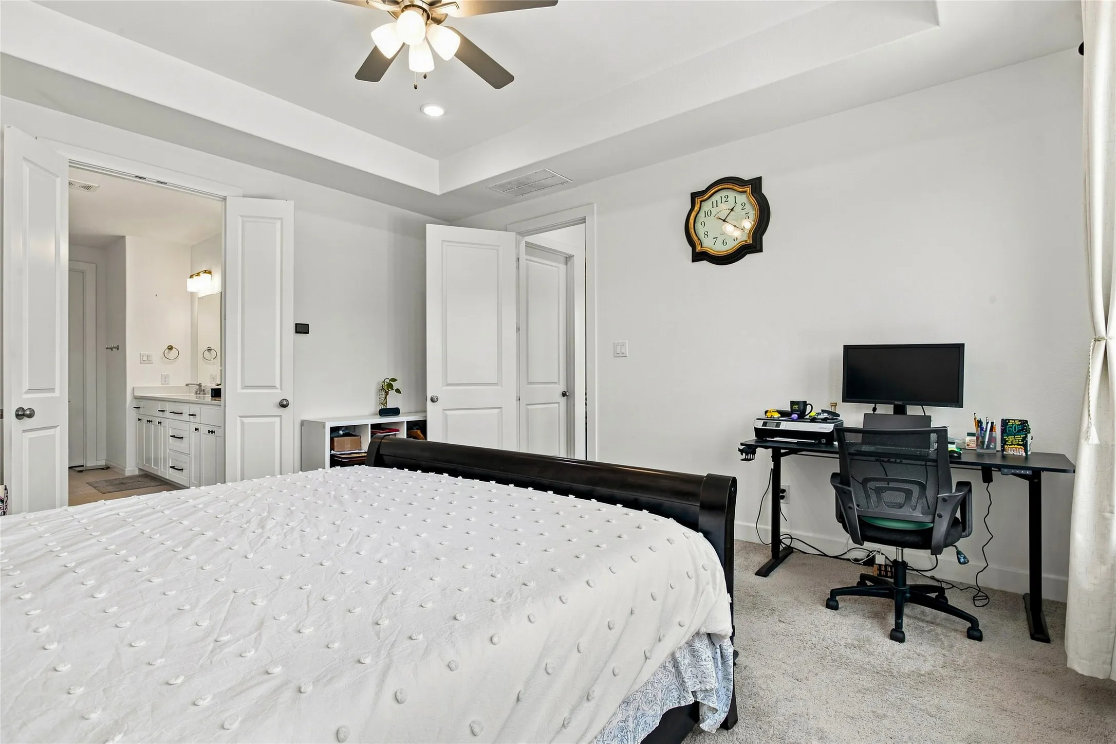 Bedroom with tray ceiling, recessed lighting, ceiling fan, and carpeted flooring