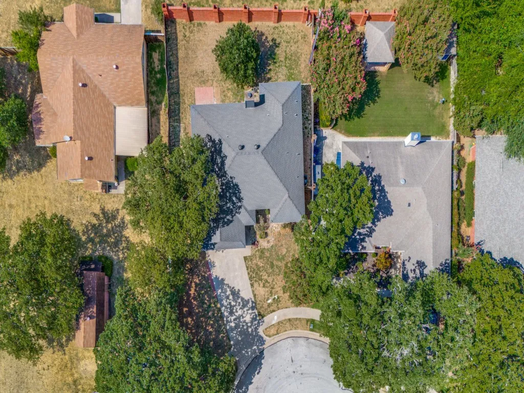 Asphalt shingle roof, mature trees, concrete driveway, fenced yard, cul-de-sac location