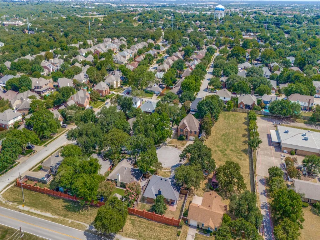 Expansive land parcel with direct road frontage, surrounded by mature trees and established residential properties