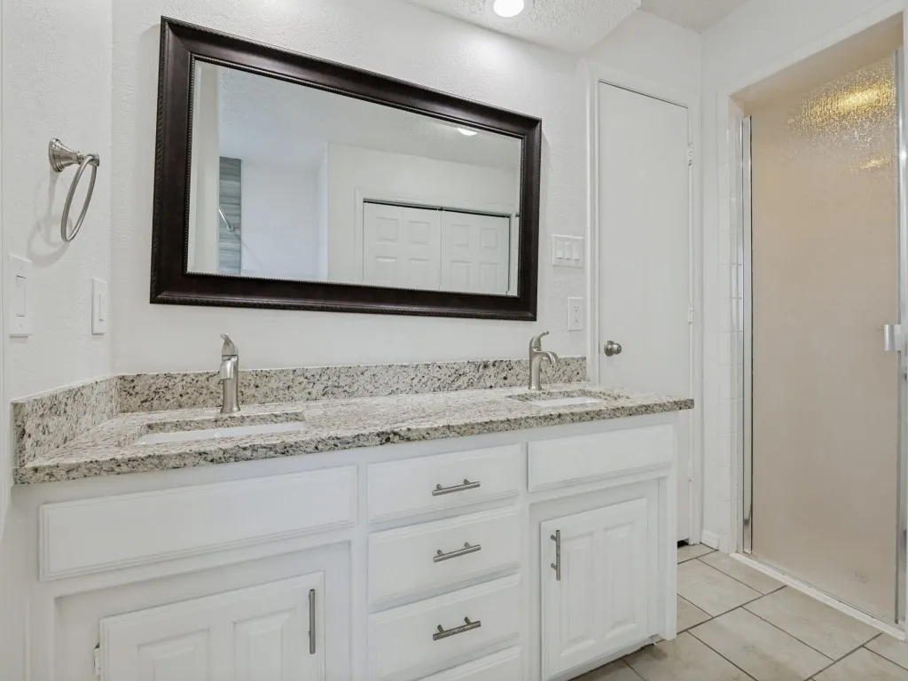 Double vanity with granite countertop, dual undermount sinks, and brushed nickel faucets
