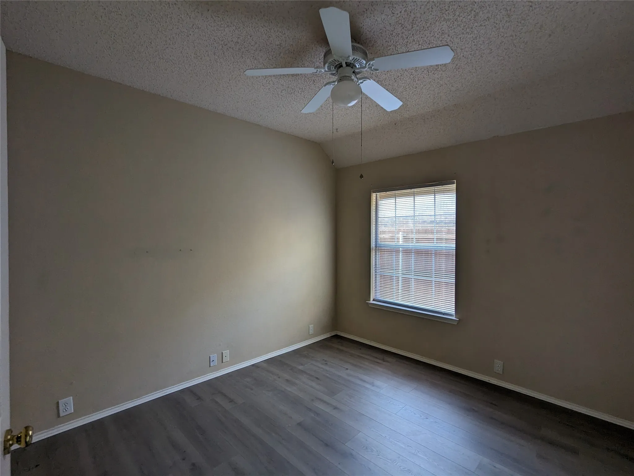 Wood-finish flooring, ceiling fan, and window with horizontal blinds