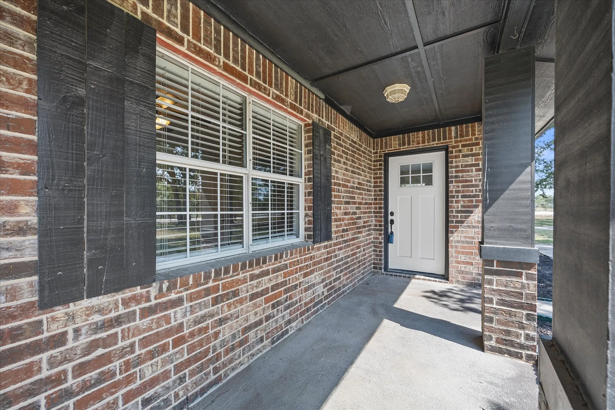 Brick exterior with contrasting dark shutters and columns