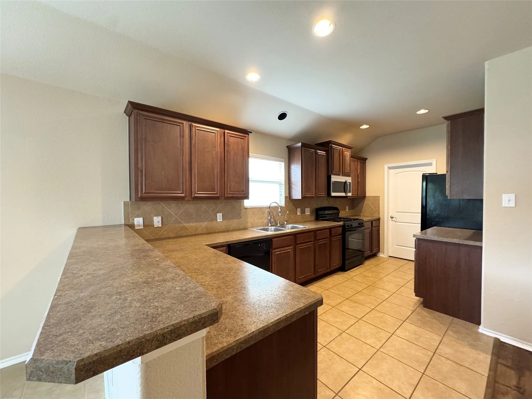 Kitchen with breakfast bar and gas cook top.