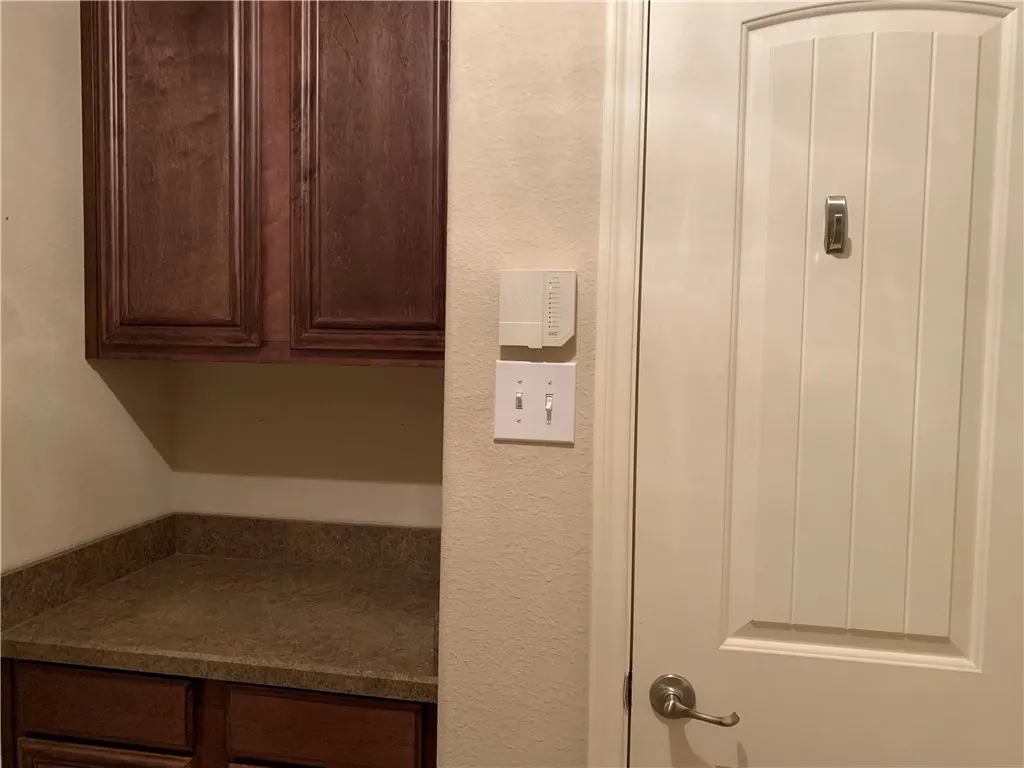 Pantry and counter space with overhead cabinets in Utility