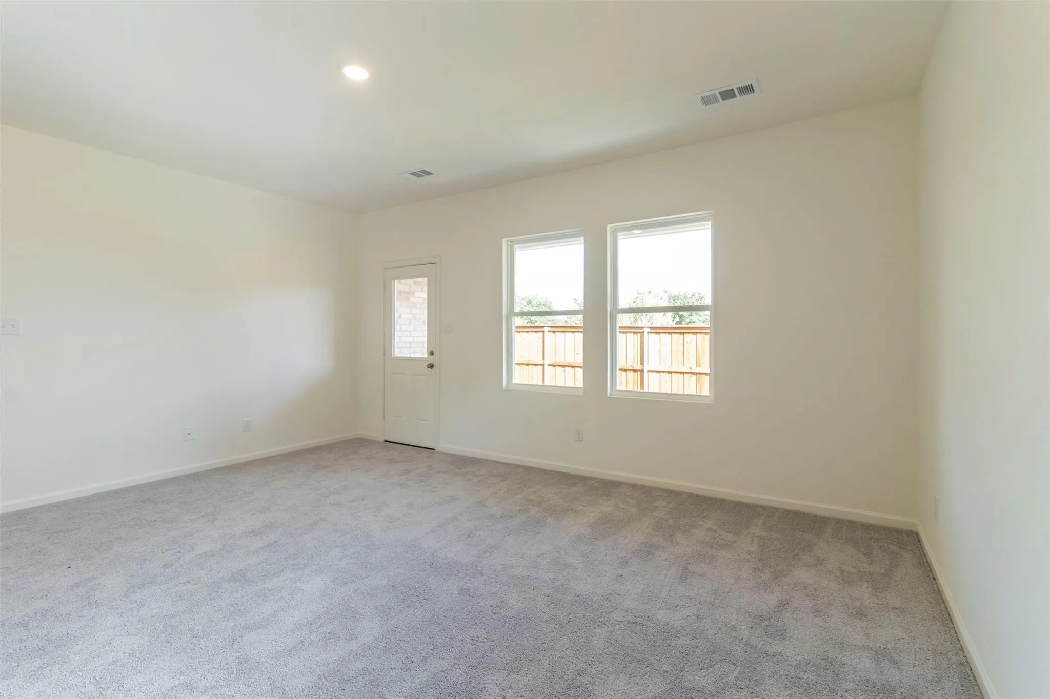 Neutral wall finishes, recessed lighting, and grey carpeting