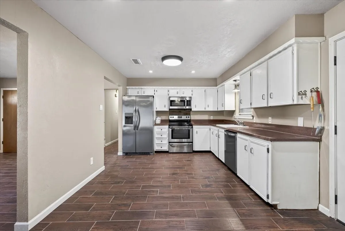 Kitchen with white cabinets and stainless style appliances