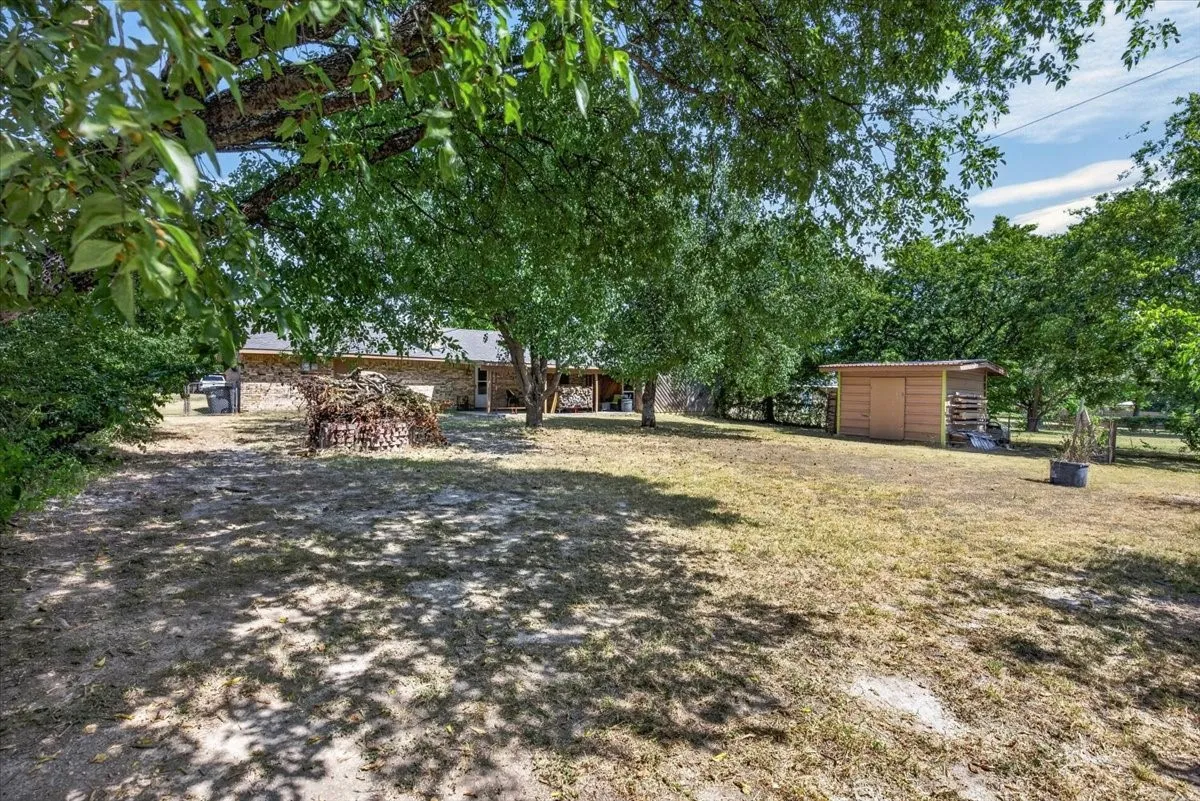 Backyard with views of the storage building and covered patio
