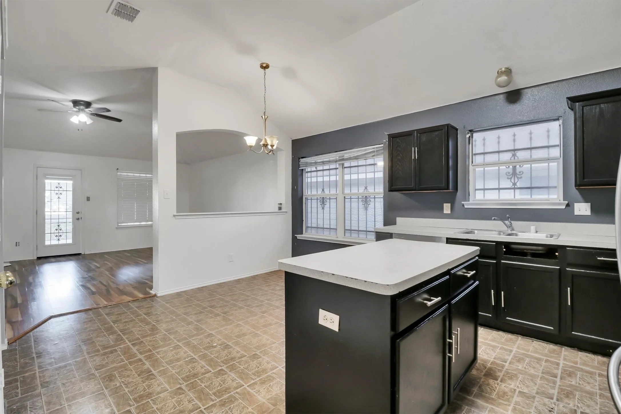 Kitchen with dark cabinetry, light countertops, and a central island