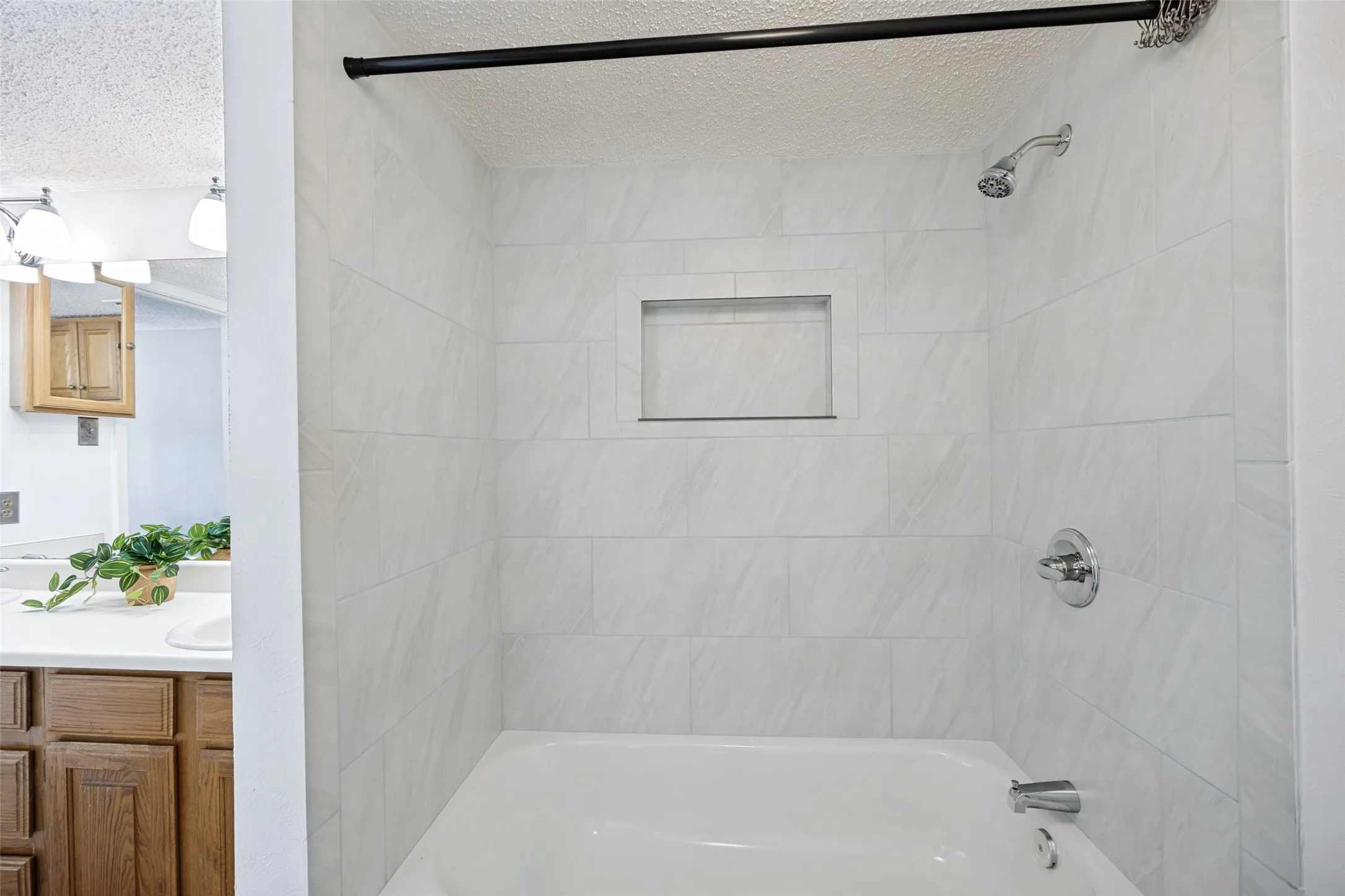 Updated Tub/shower combination featuring recessed niche