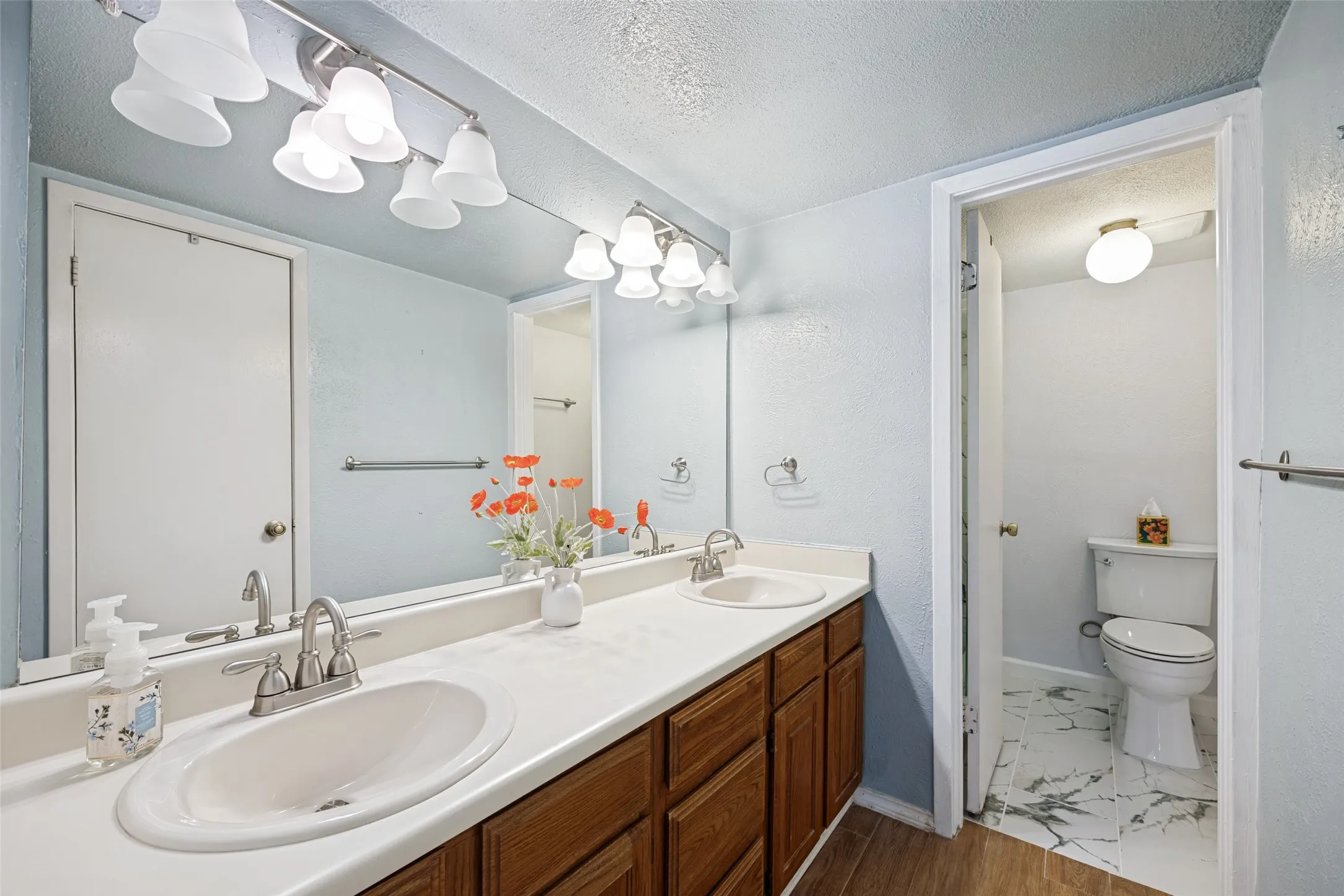 Large vanity with 2 sinks is separate from updated shower area and has a linen closet not seen