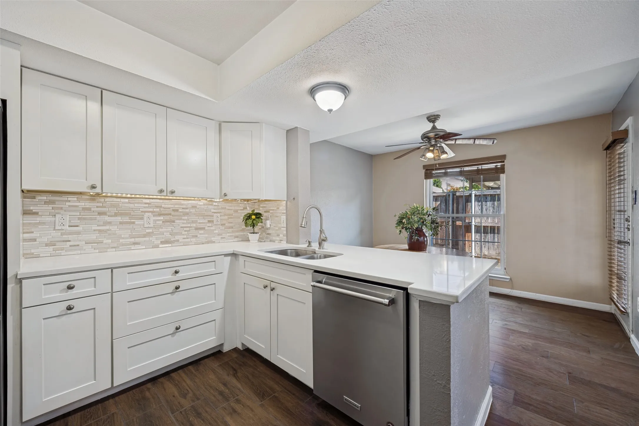 Updated Kitchen! Tons of storage and counter space featuring white shaker-style cabinetry, a mosaic tile backsplash, and stainless steel appliances