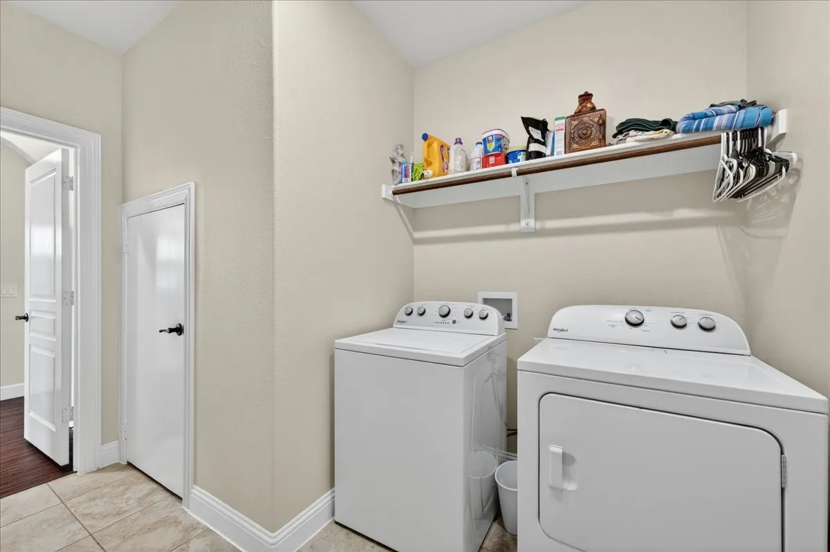 Dedicated laundry area featuring tile flooring and neutral wall tones