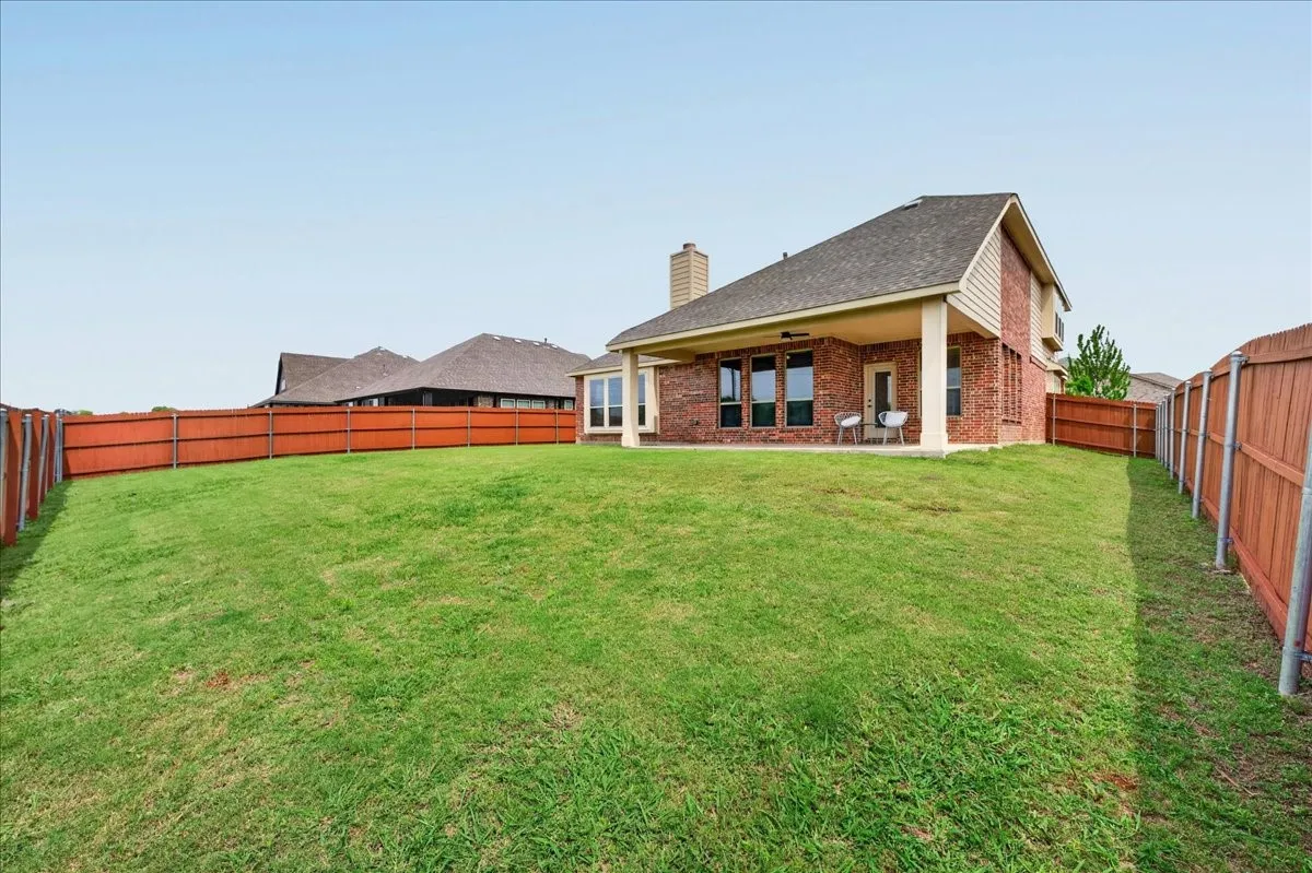 Expansive green lawn with a full wooden privacy fence