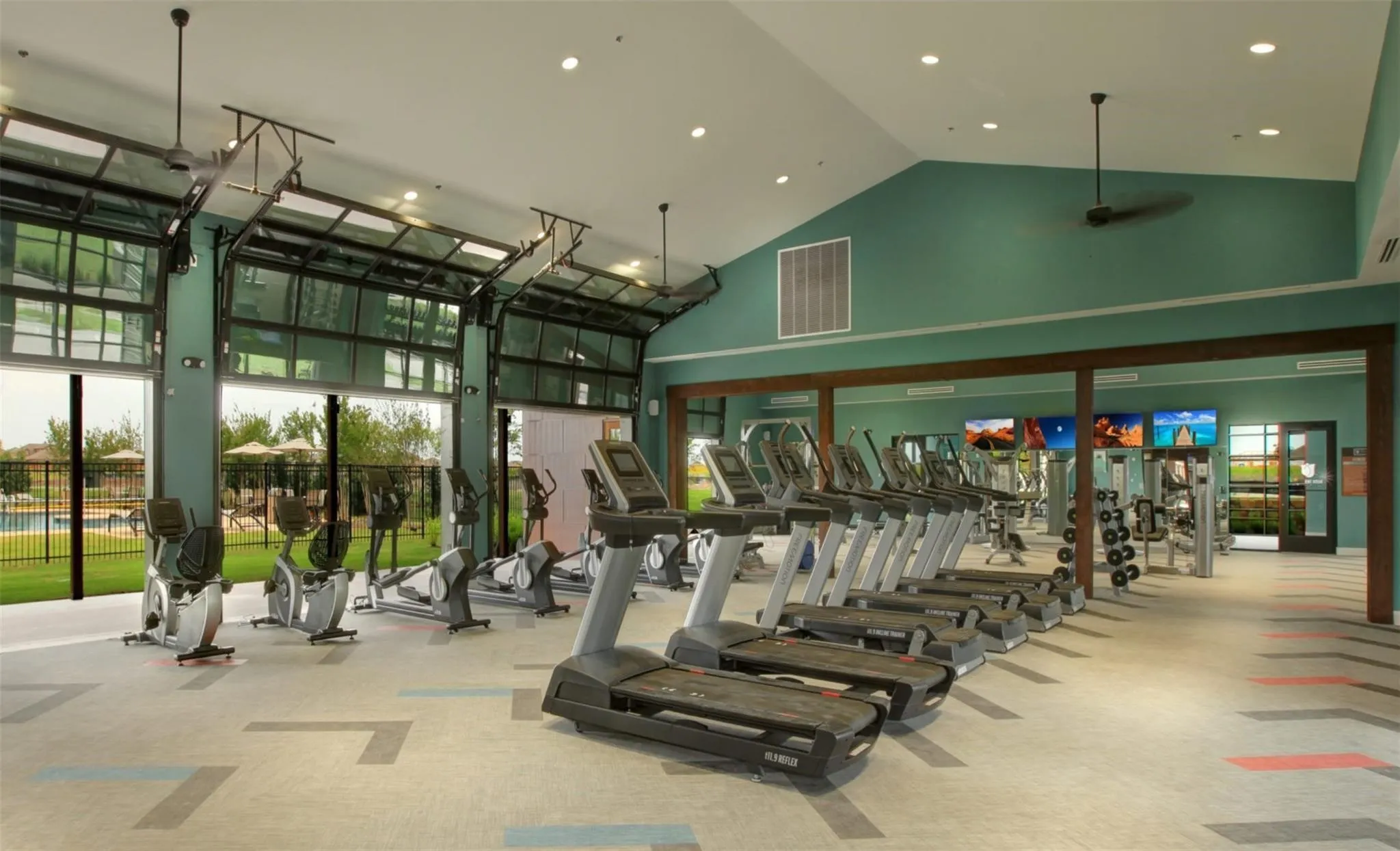Fitness center featuring a vaulted ceiling and an array of cardio equipment