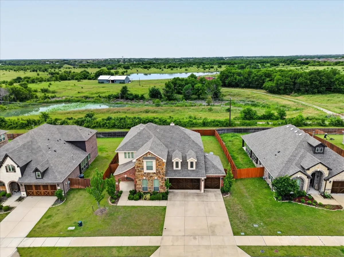 Two-story residence featuring a stone and brick facade, an attached two-car garage, and a concrete driveway
