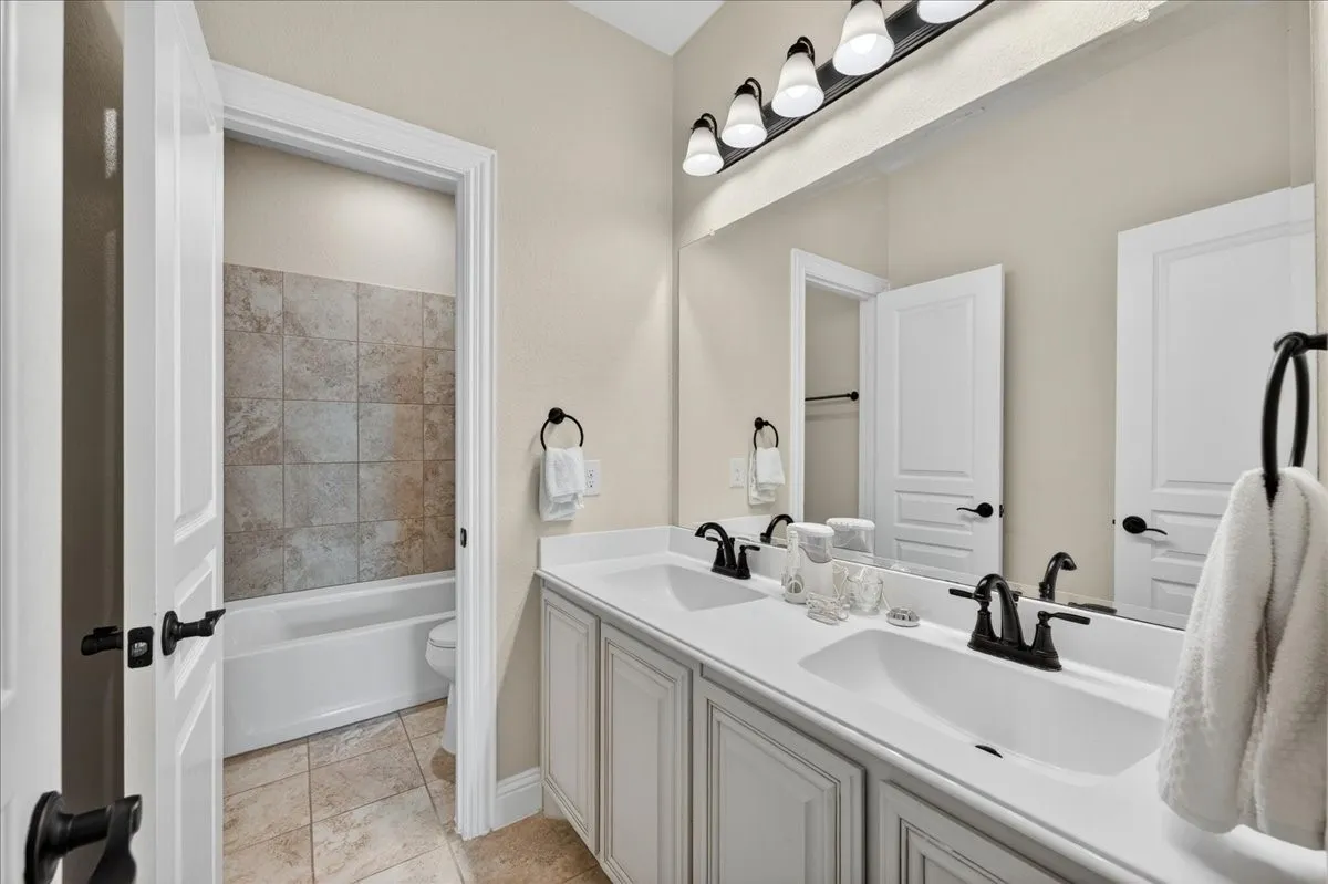 Double vanity with integrated sinks, white countertops, and matte black fixtures