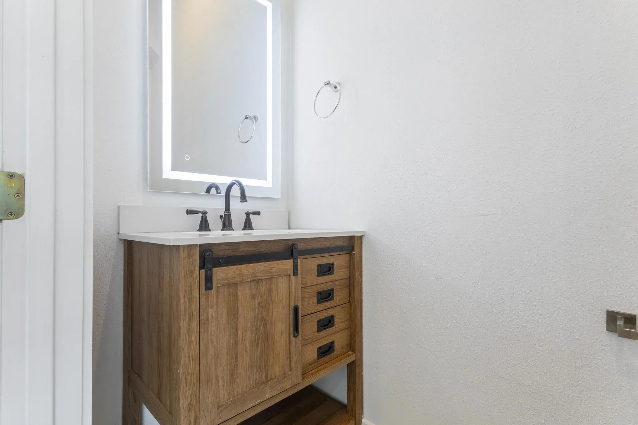 Wood-finish vanity with a white countertop and undermount sink