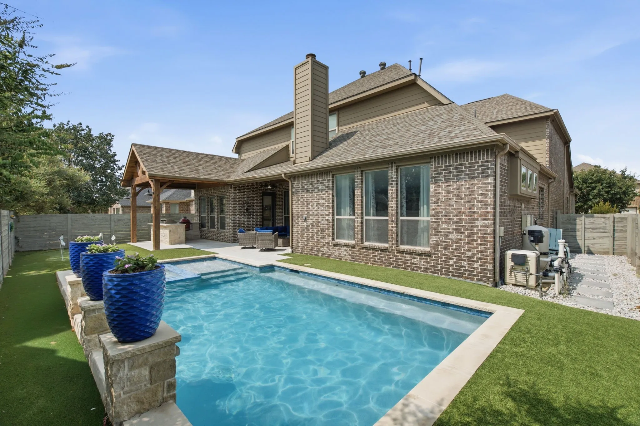 Beautiful pool with turf backyard