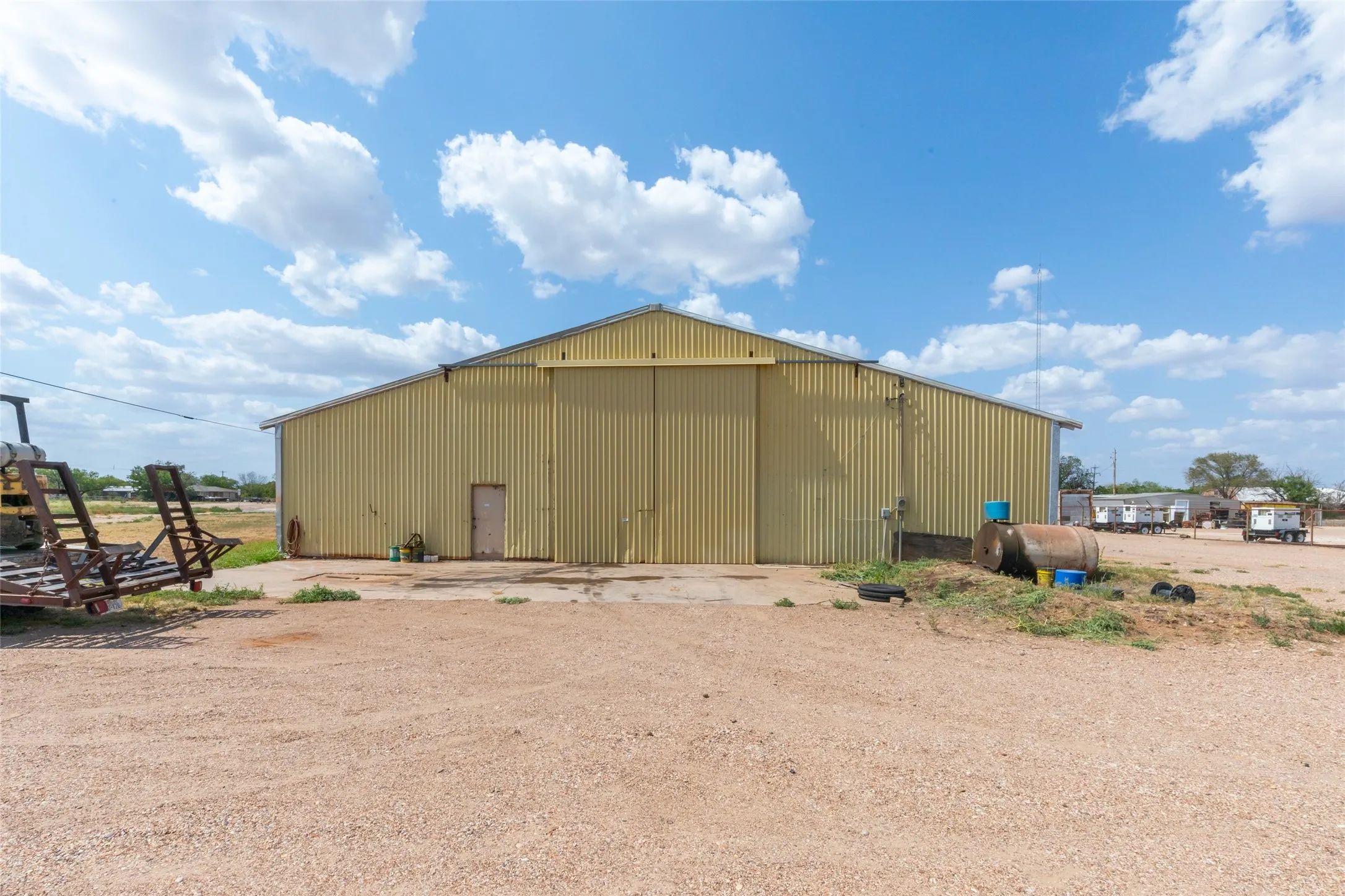 Metal-sided industrial building with a large sliding door, concrete pad, and a separate entry door