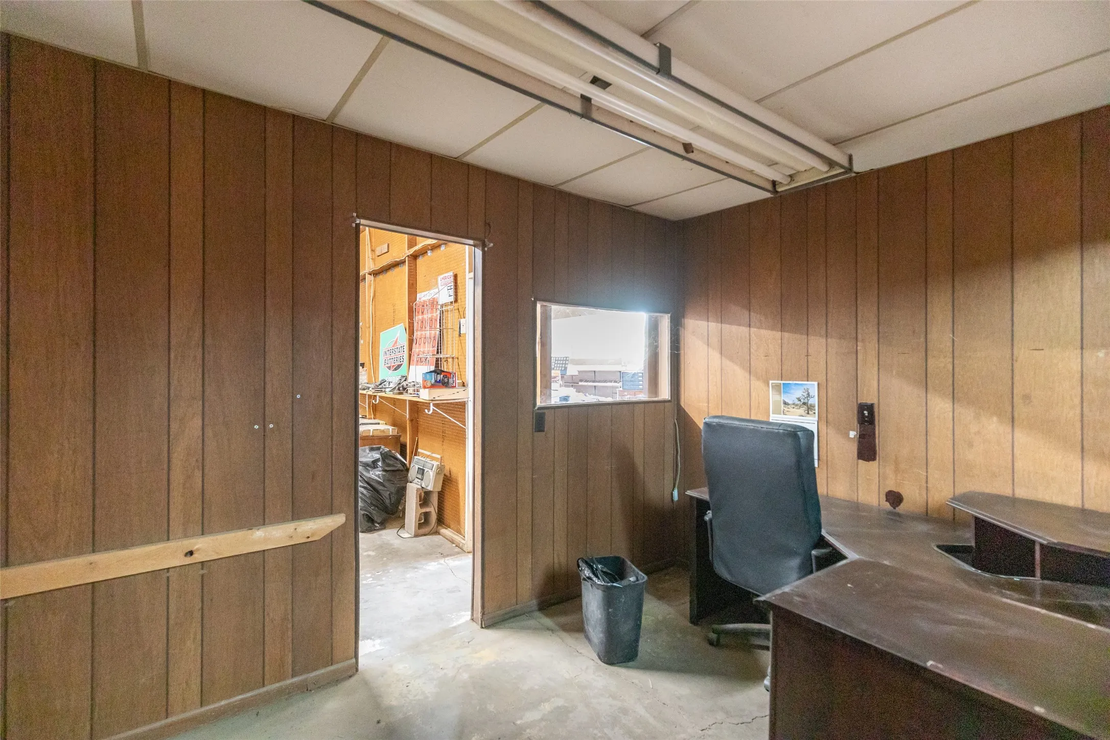 Wood-paneled walls and a drop ceiling with fluorescent lighting