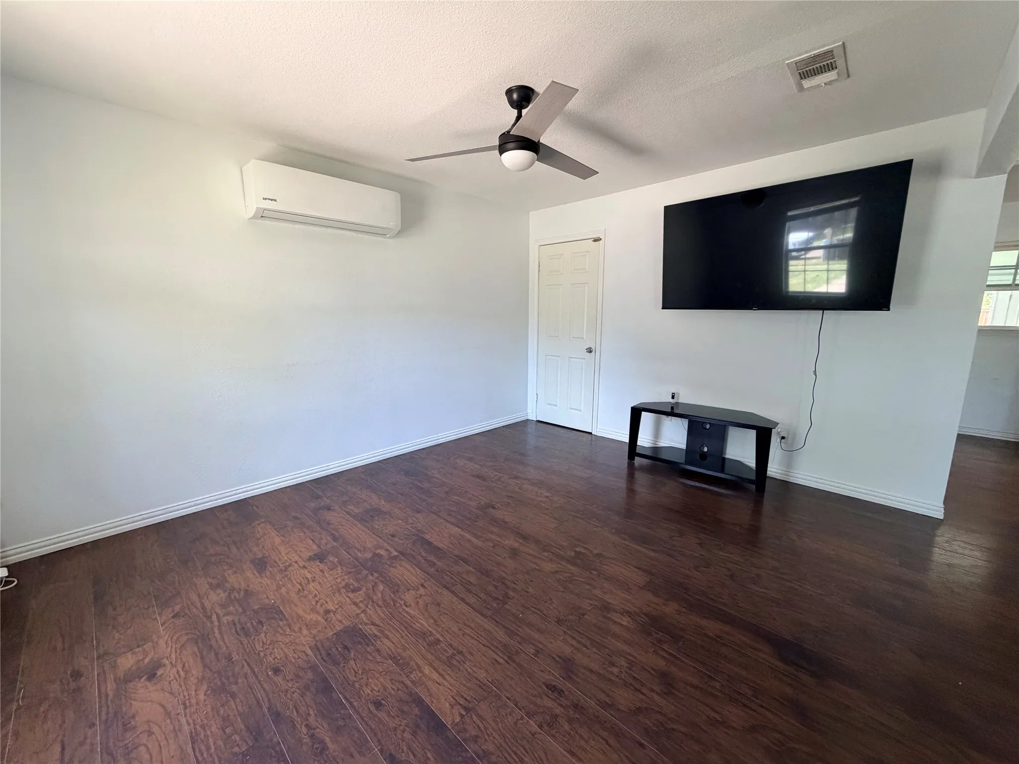 Wood-finish flooring throughout, complemented by a ceiling fan with integrated lighting