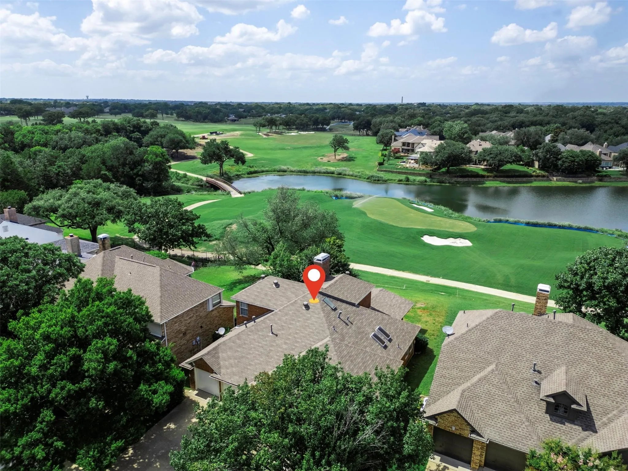 Aerial perspective showcasing golf course frontage with a pond and lush green fairways