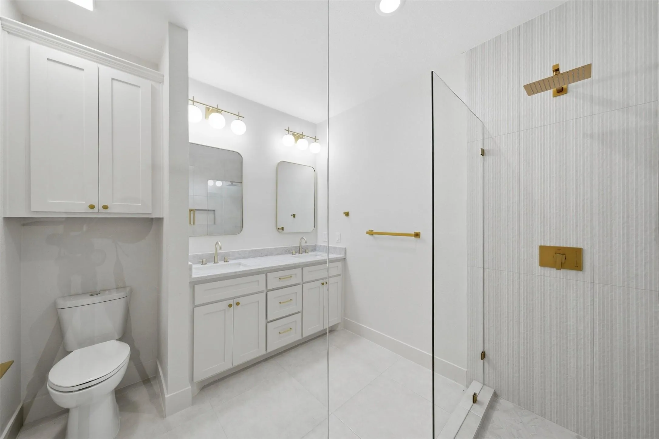 Dual vanity with white cabinetry and gold-tone hardware