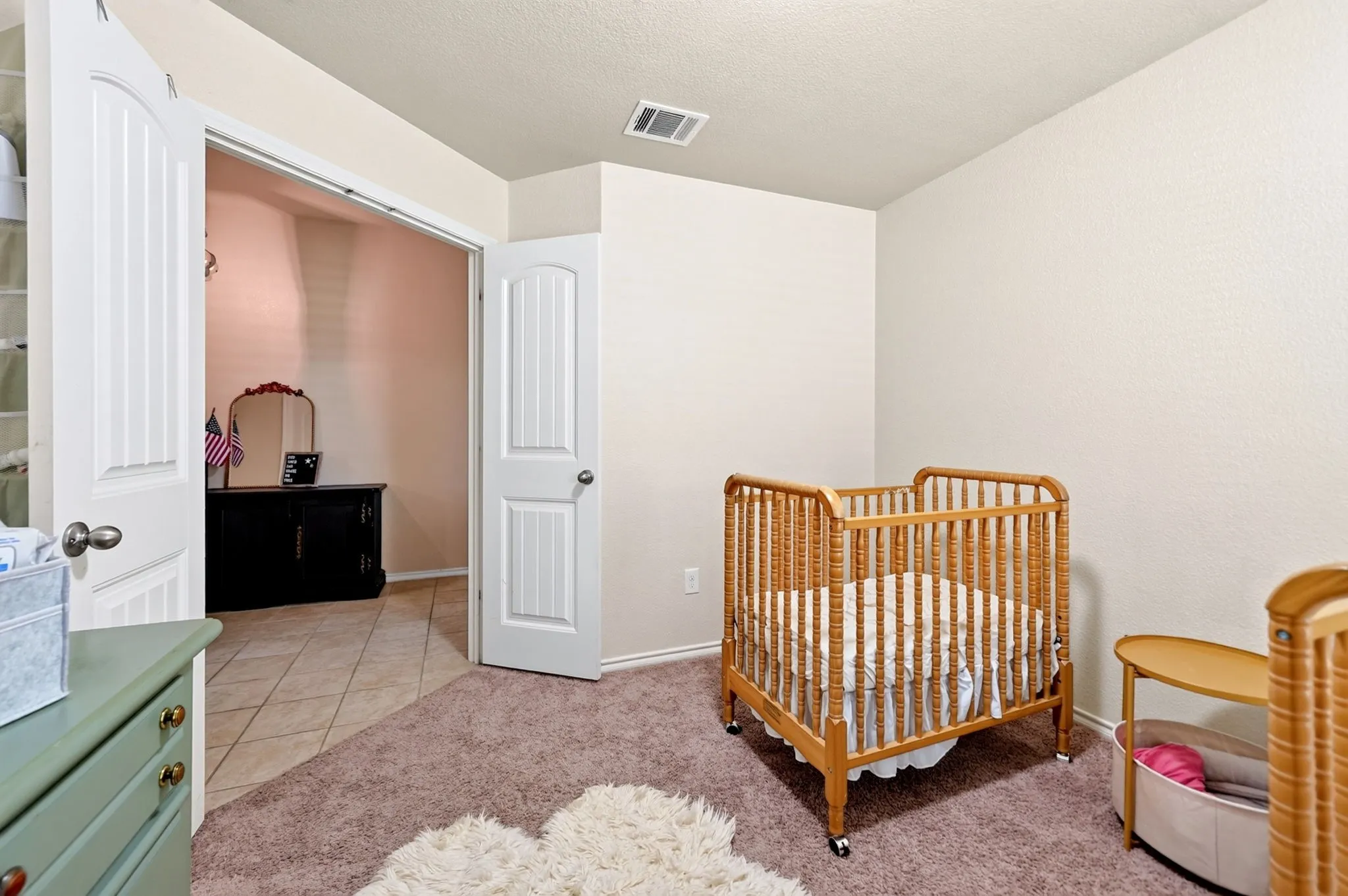 Soft carpeting underfoot and textured walls enhance the room's comfort
