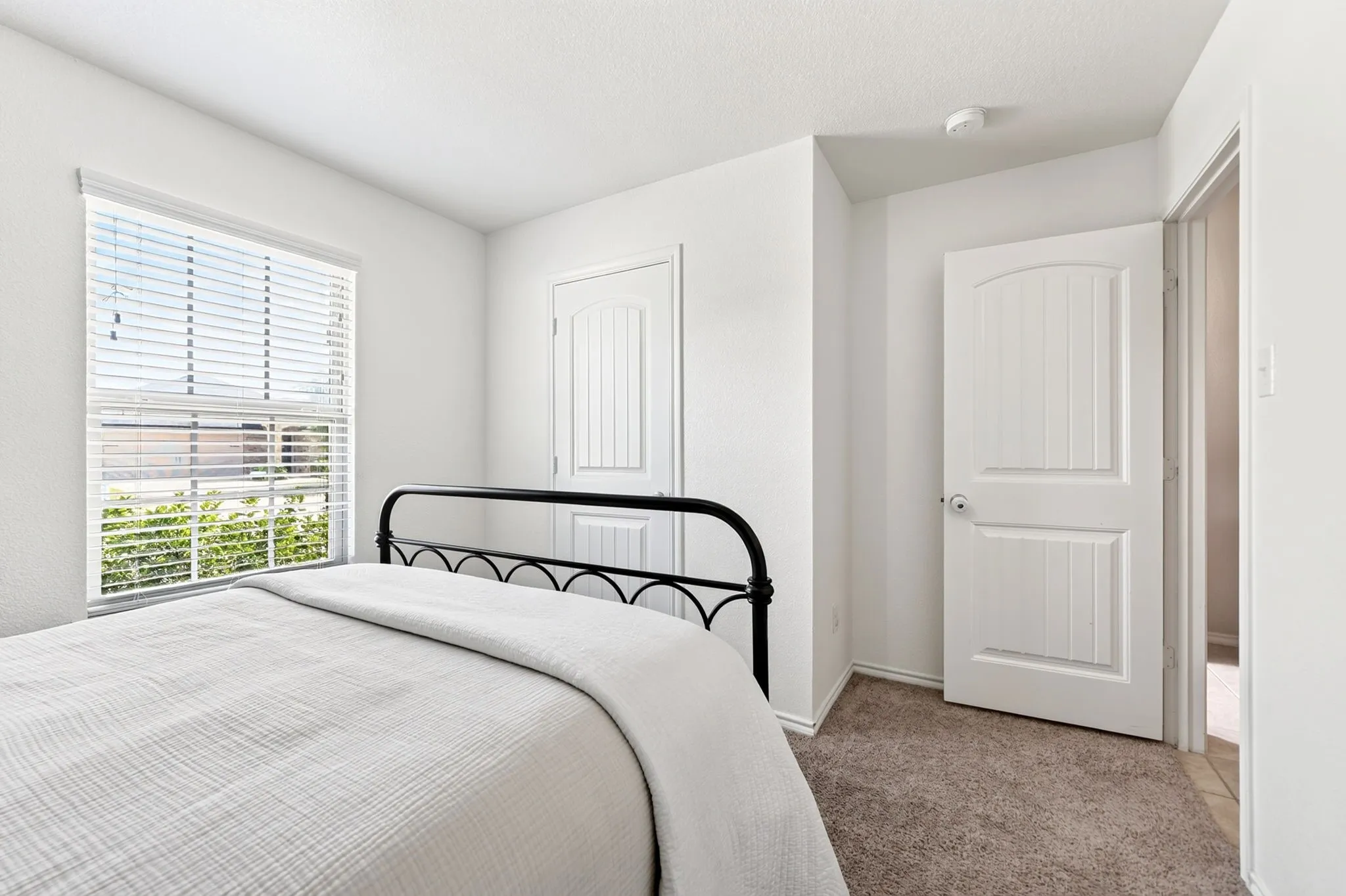 Window with horizontal blinds, textured walls, and carpet flooring