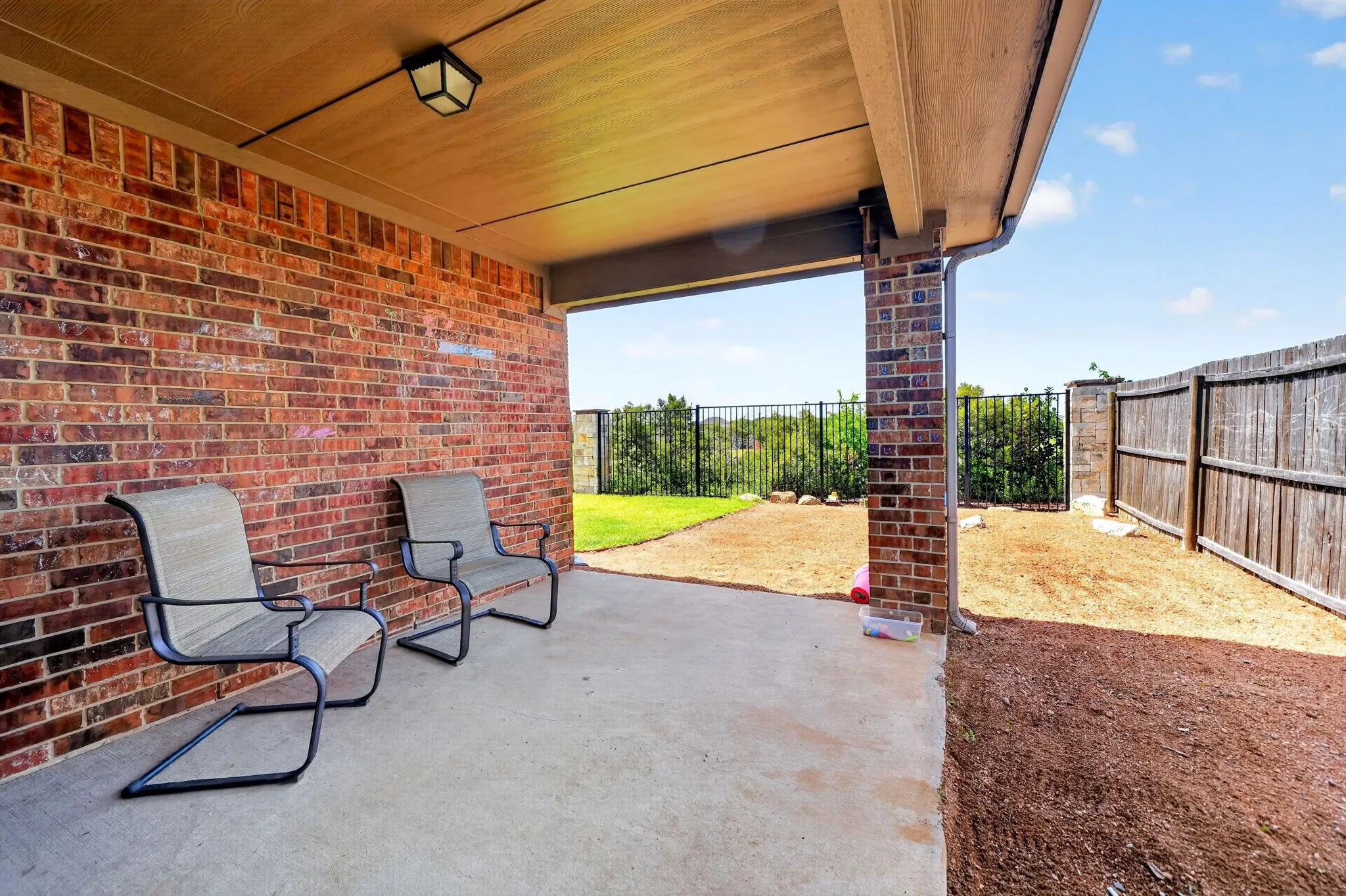 Covered patio with a concrete surface and brick exterior wall
