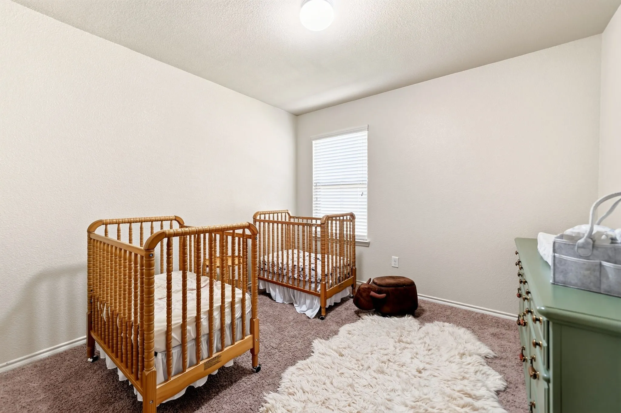 Neutral tone wall paint, carpeted flooring, single window with blinds, recessed ceiling light