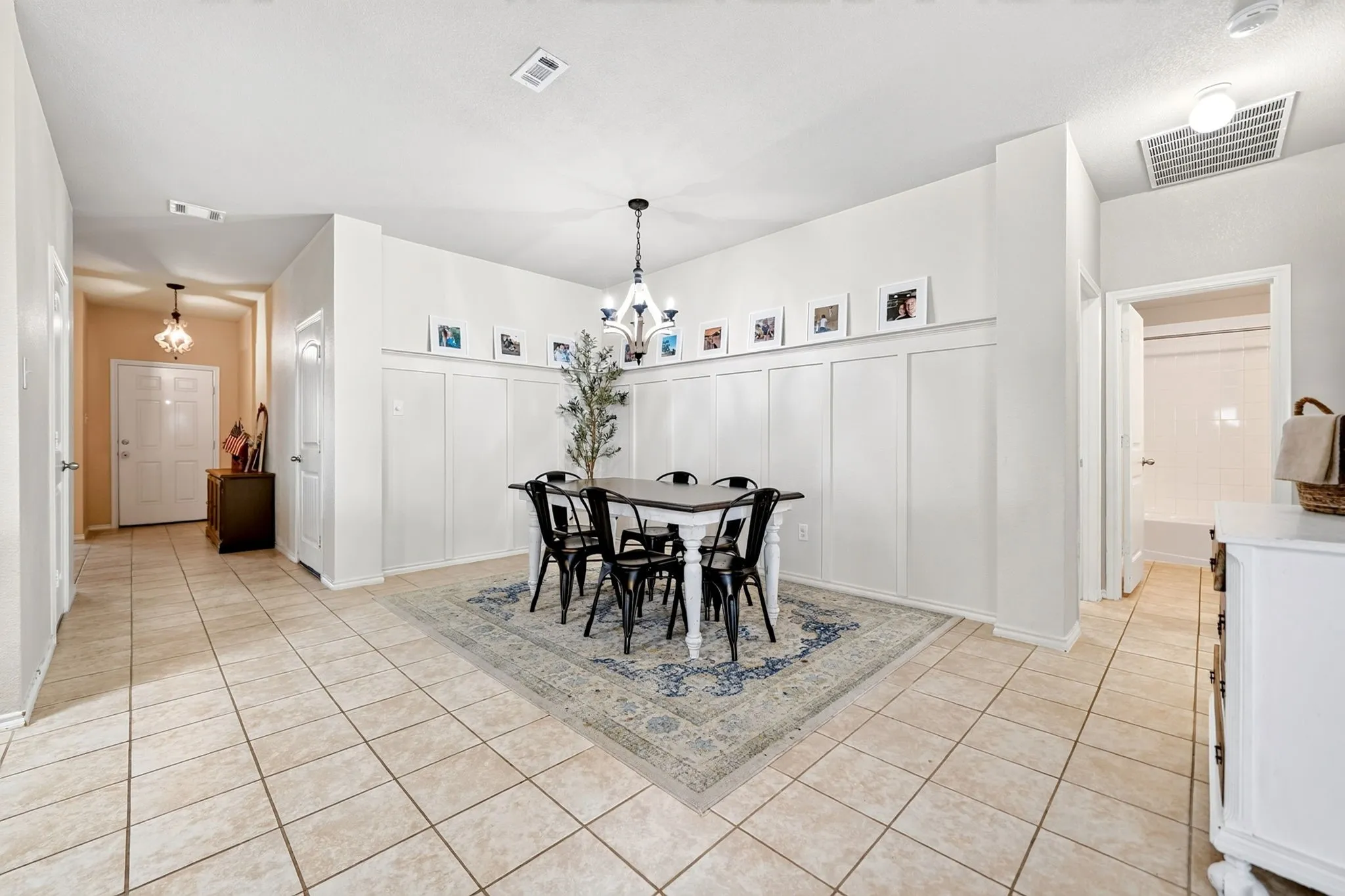 Tile flooring extending throughout, chandelier lighting, and wainscoting paneling
