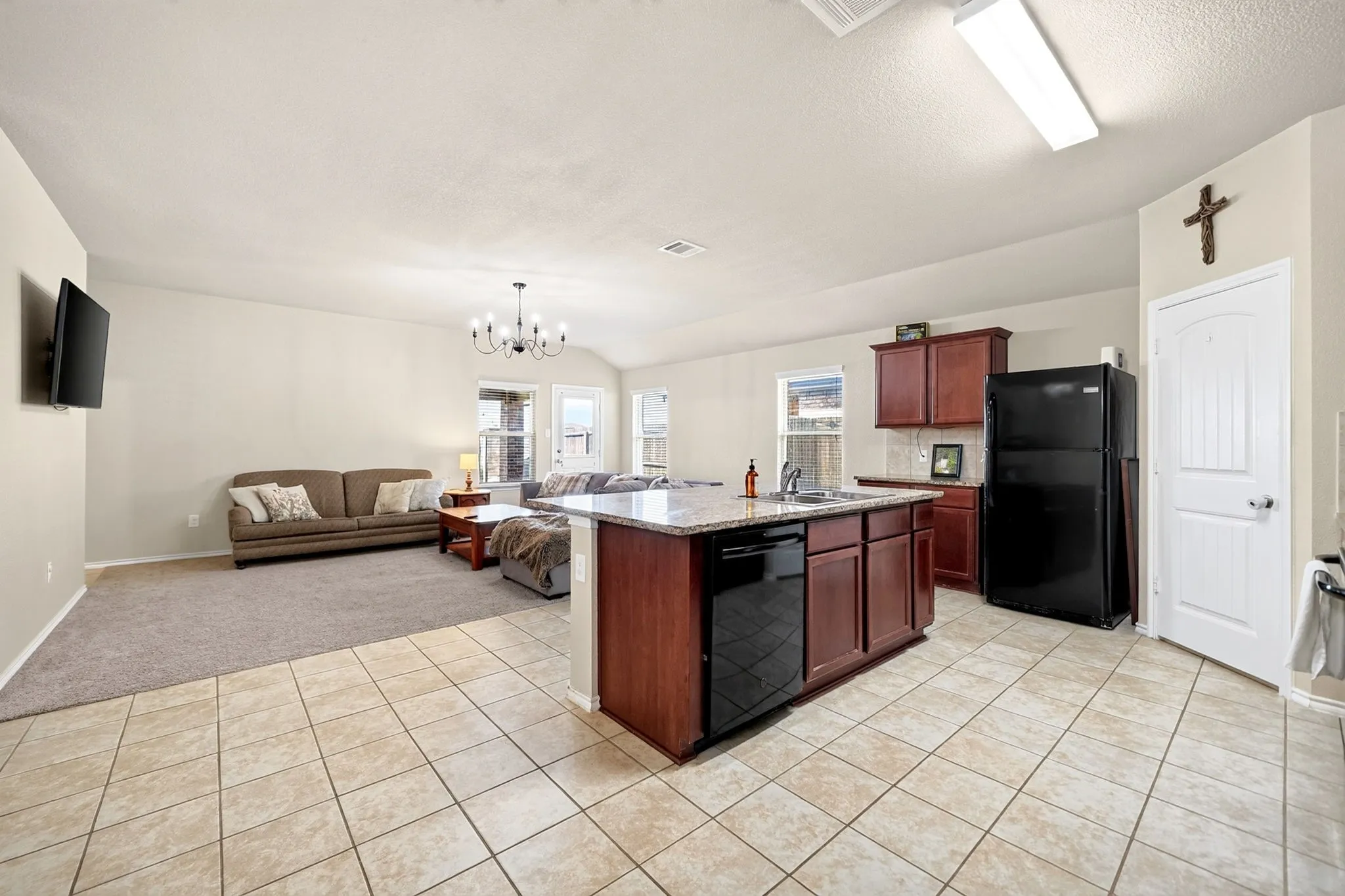 Open-concept living area with tile and carpeted flooring