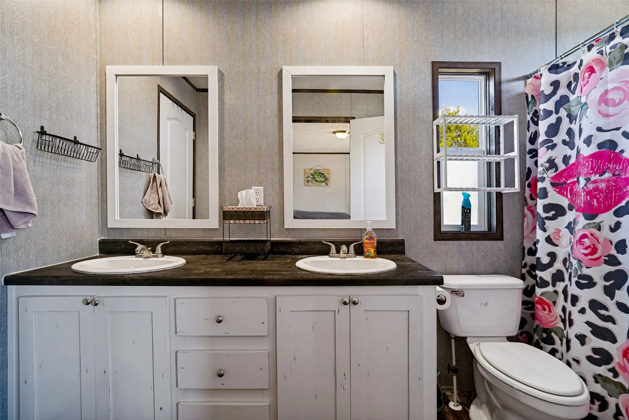Dual vanity with white cabinetry, dark countertop, and integrated sinks