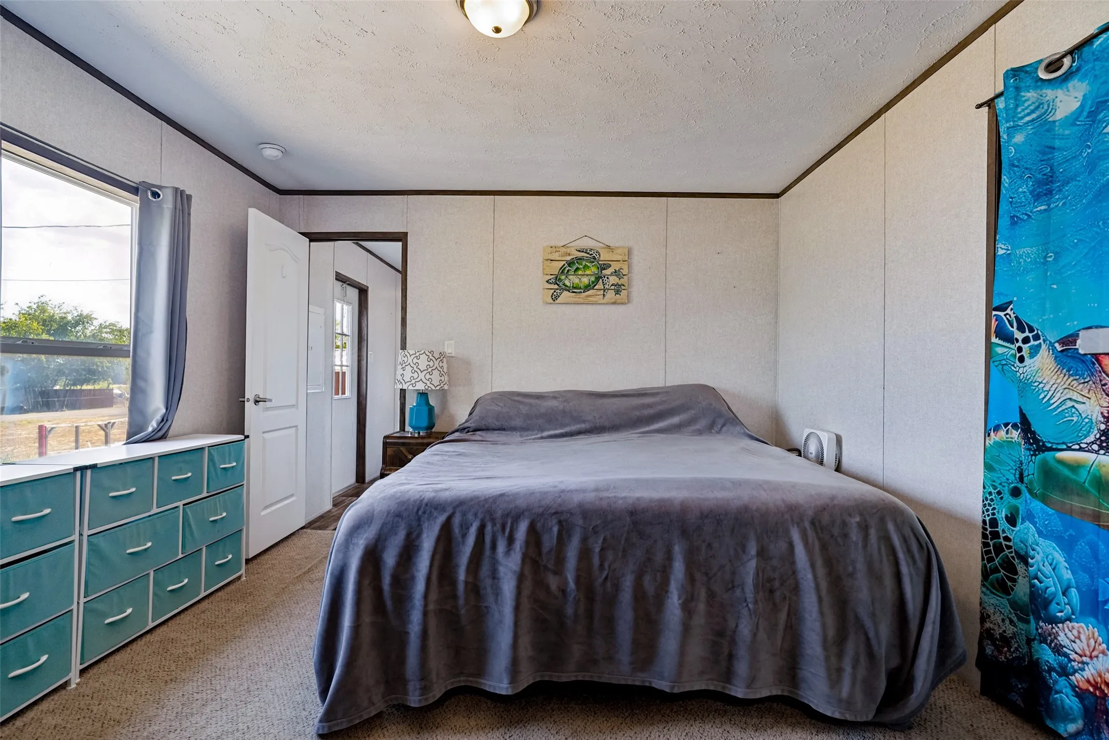 Carpeted flooring, paneled walls, and a ceiling-mounted light fixture