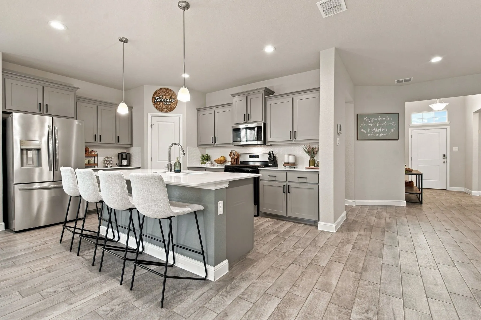 Kitchen featuring stainless steel appliances, an island with seating, pendant lighting, recessed lighting, and wood-finish flooring