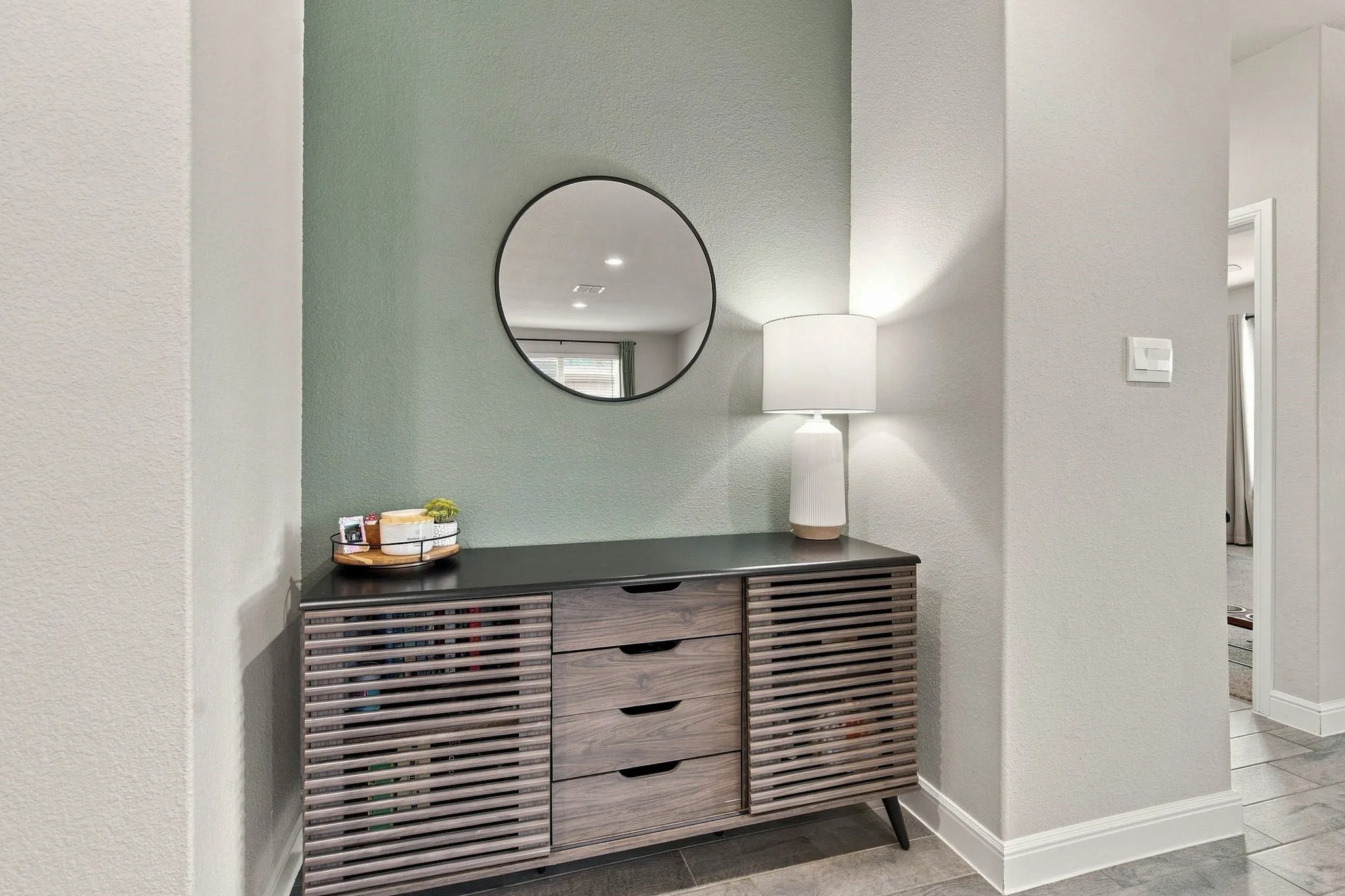 Built-in alcove featuring a decorative mirror, neutral wall paint, and recessed lighting