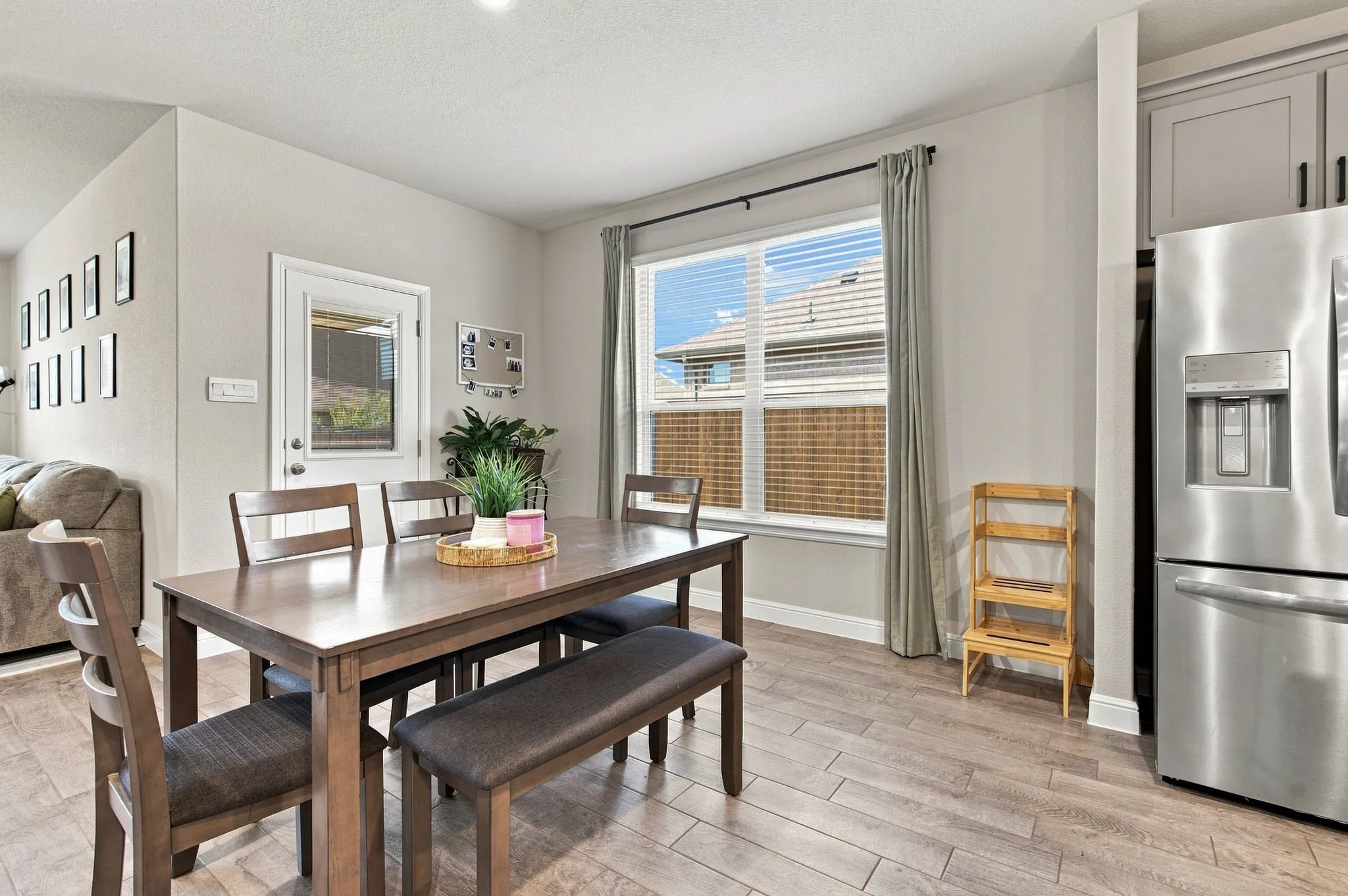 Stainless steel refrigerator, gray shaker-style cabinetry, and wood-finish flooring