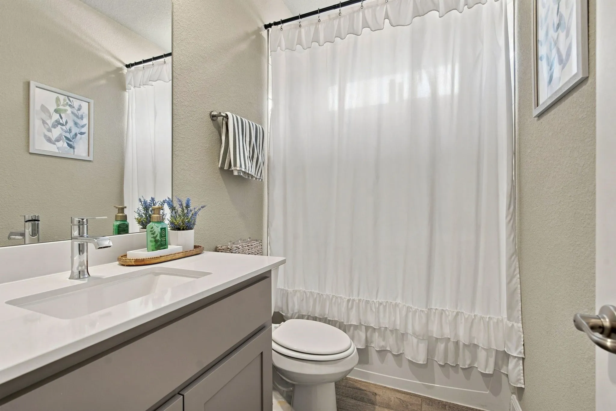 Vanity with an integrated rectangular sink, chrome faucet, and gray cabinetry