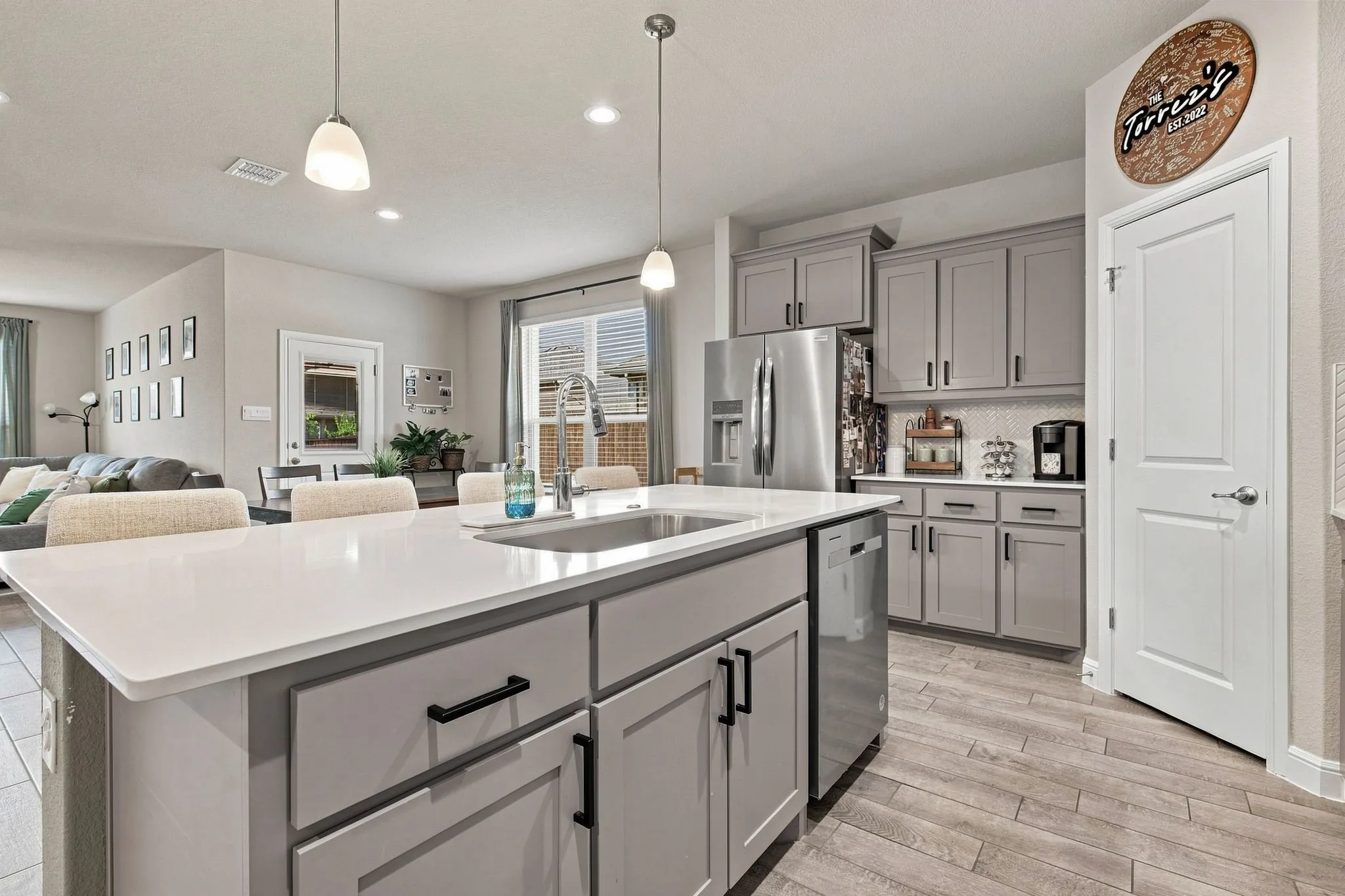 Kitchen island with a white solid surface countertop and undermount sink