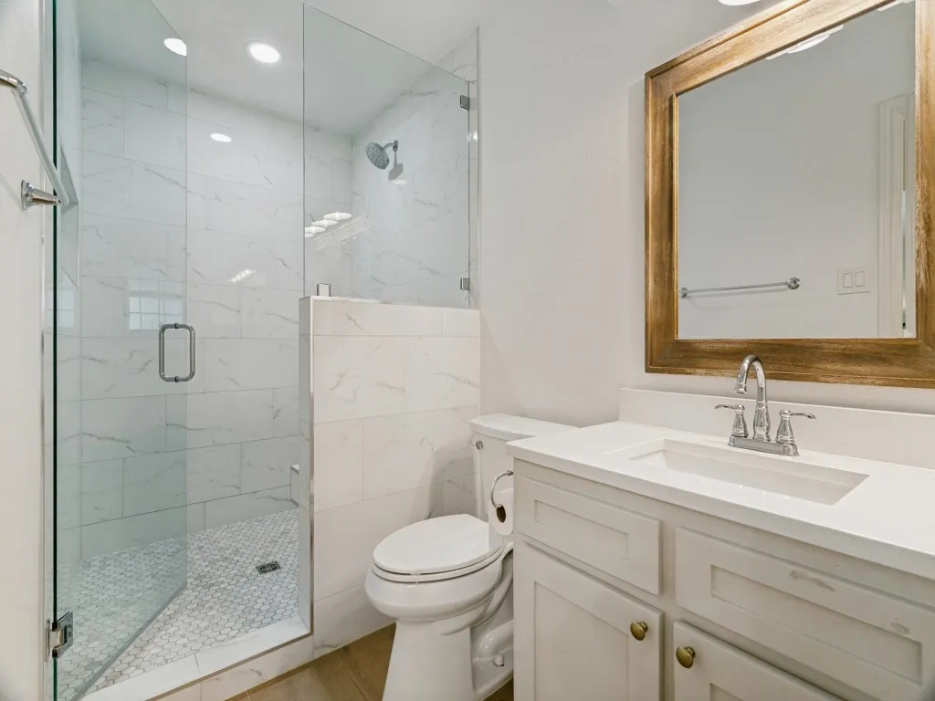 A large frameless glass shower completes the refreshed primary bath.