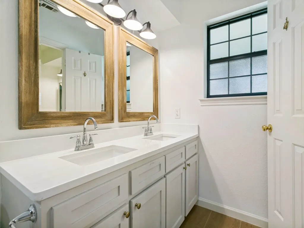 Dual sinks with quartz countertops provide ample space for busy mornings.