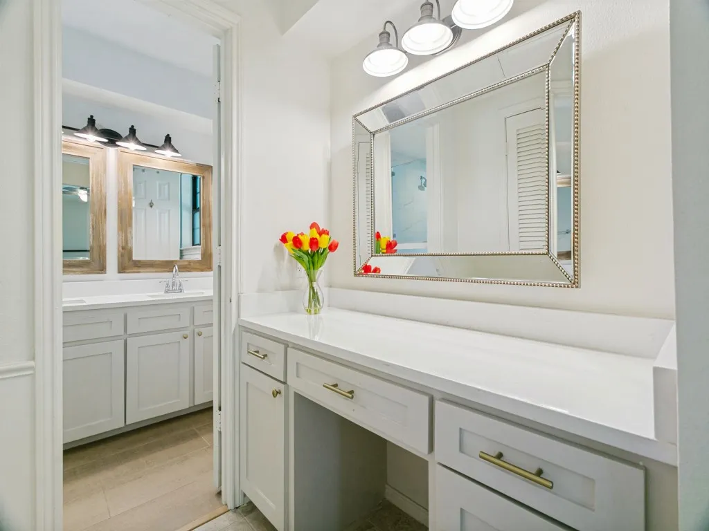 The updated primary bath includes a separate seated makeup vanity and plenty of storage.