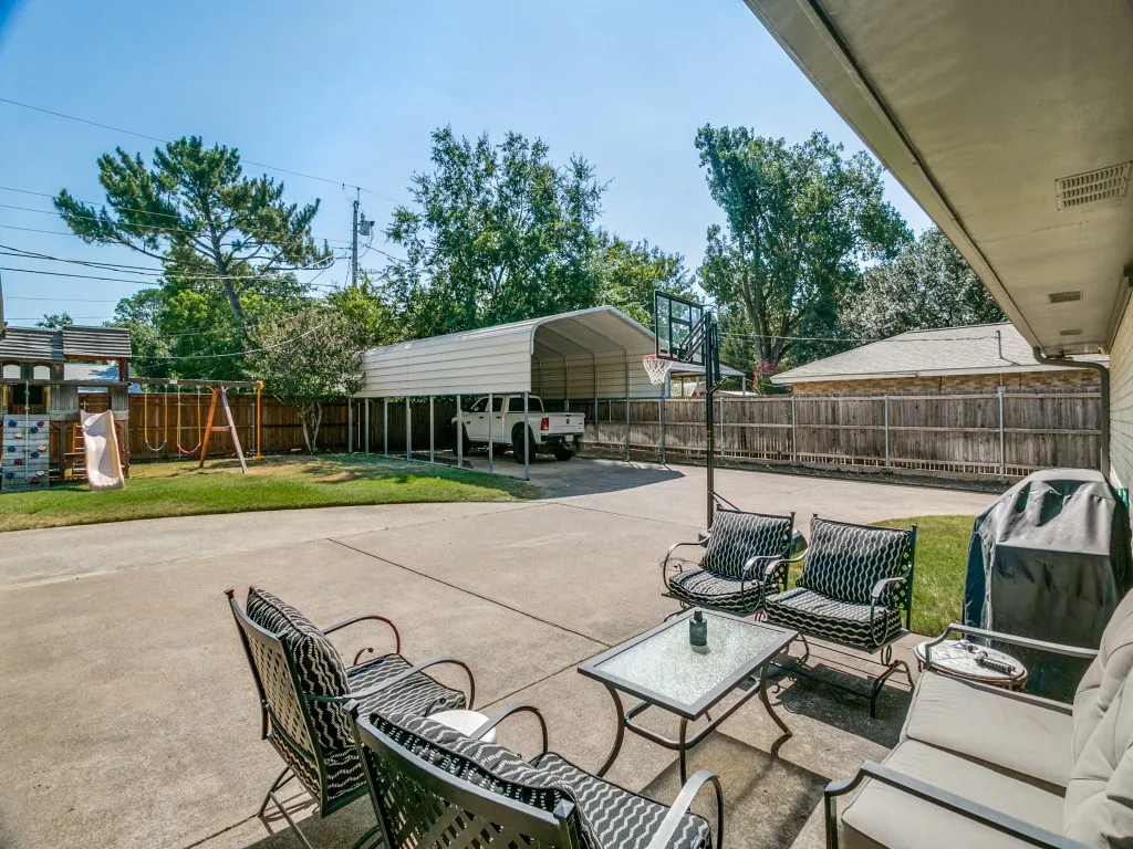 Behind the gated driveway, an expansive paved area provides exceptional parking and outdoor flexibility.